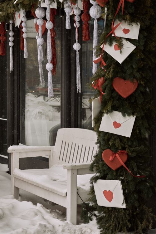 Free Festive winter scene with heart decorations and snow-covered bench, evoking holiday warmth. Stock Photo