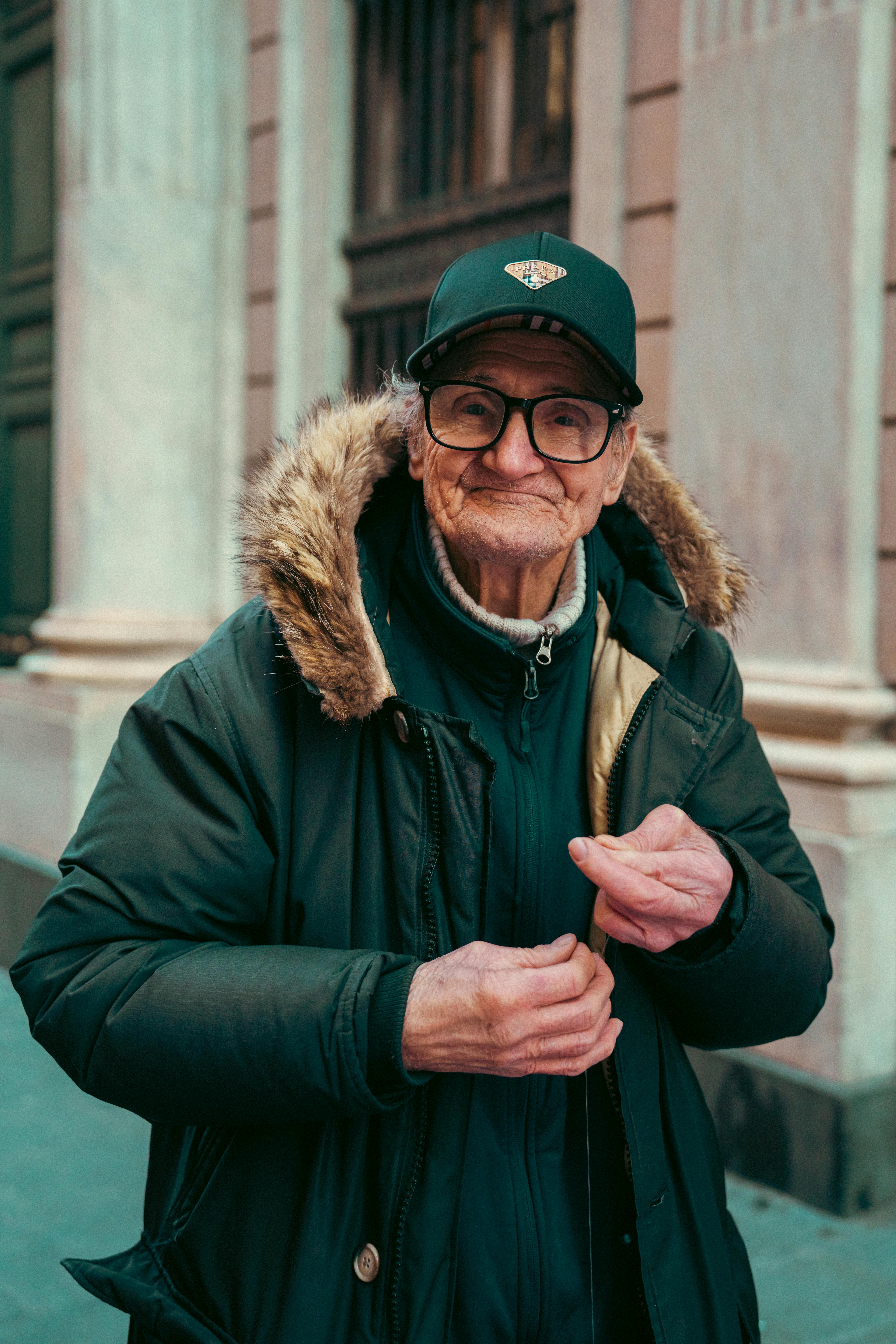 Kostenlos Porträt eines älteren Mannes mit Wintermantel und Brille, der im Freien in Genua, Italien, steht. Stock-Foto
