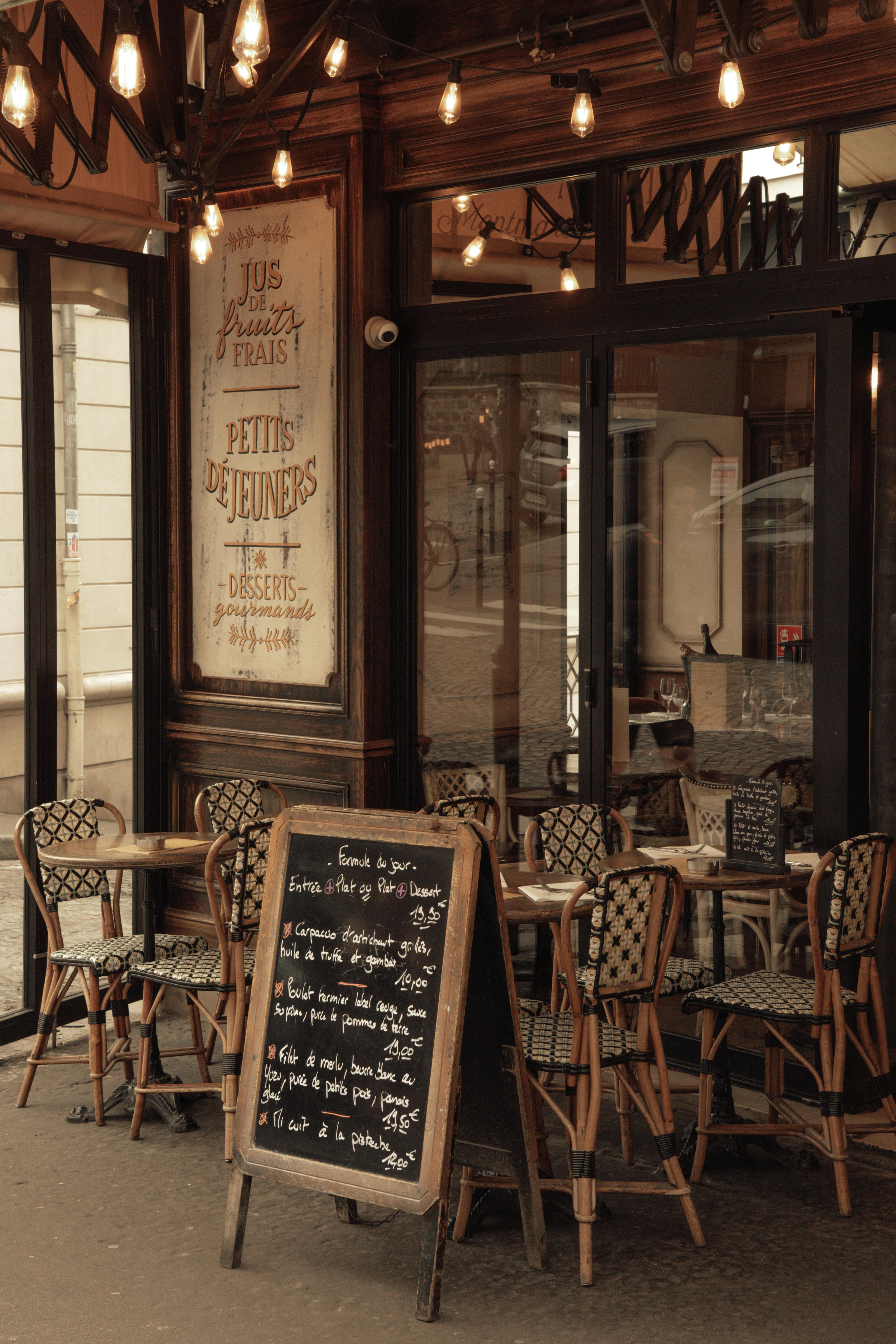 Δωρεάν Άνετο παριζιάνικο καφέ με κλασικά καθίσματα εξωτερικού χώρου και φιλόξενο μενού σε μαυροπίνακα. Φωτογραφία από στοκ φωτογραφιών