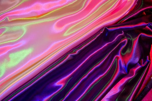 Colorful satin fabric displays a vibrant, shimmering texture under creative lighting, ideal for abstract backgrounds.