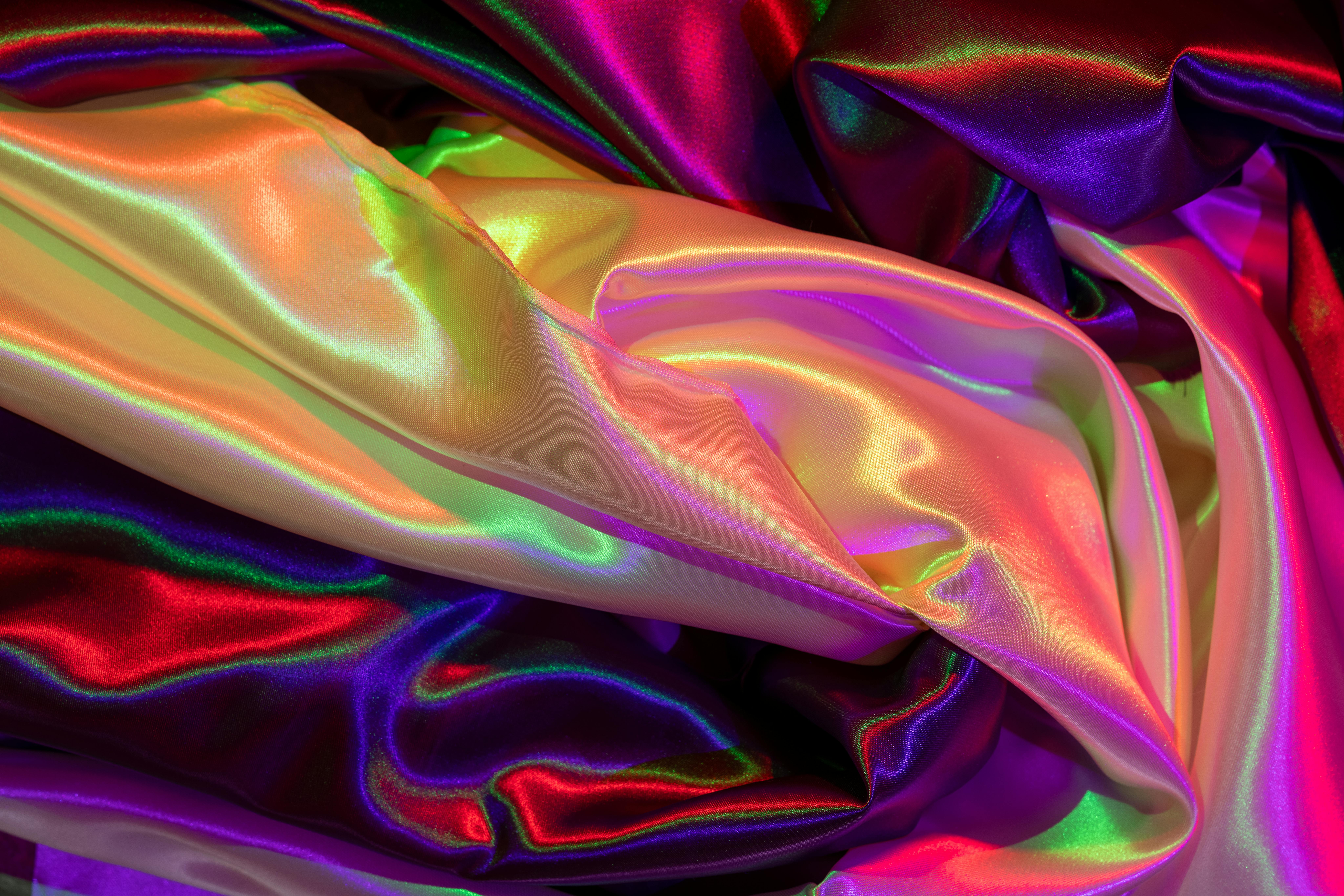 Gratis Nærbilde av fargerikt satengstoff med iriserende glans og livlige mønstre. Arkivbilde