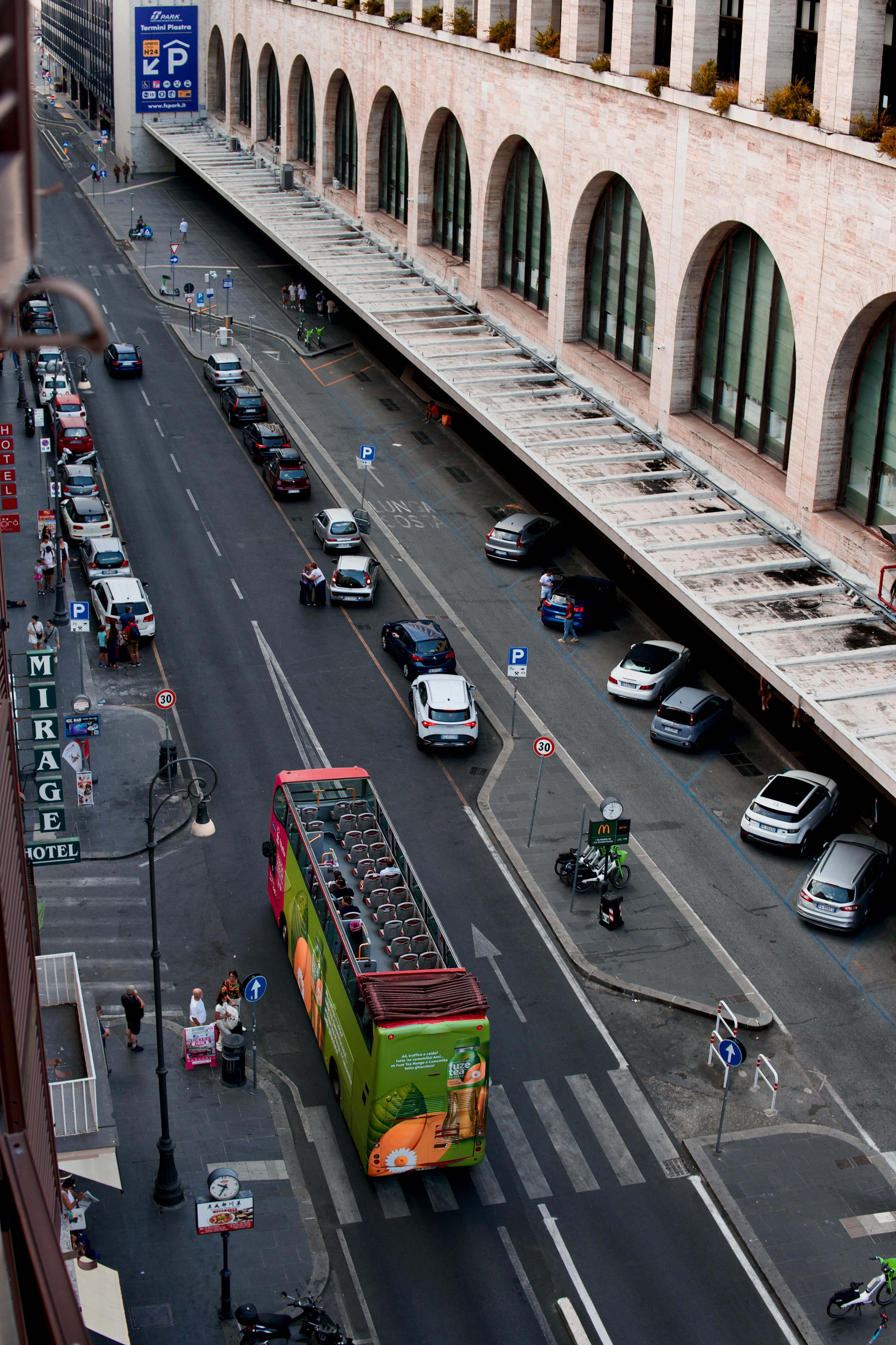 Δωρεάν Φωτογραφία υψηλής γωνίας ενός πολυσύχναστου δρόμου στη Ρώμη με ένα λεωφορείο με ανοιχτή οροφή και σταθμευμένα αυτοκίνητα. Φωτογραφία από στοκ φωτογραφιών