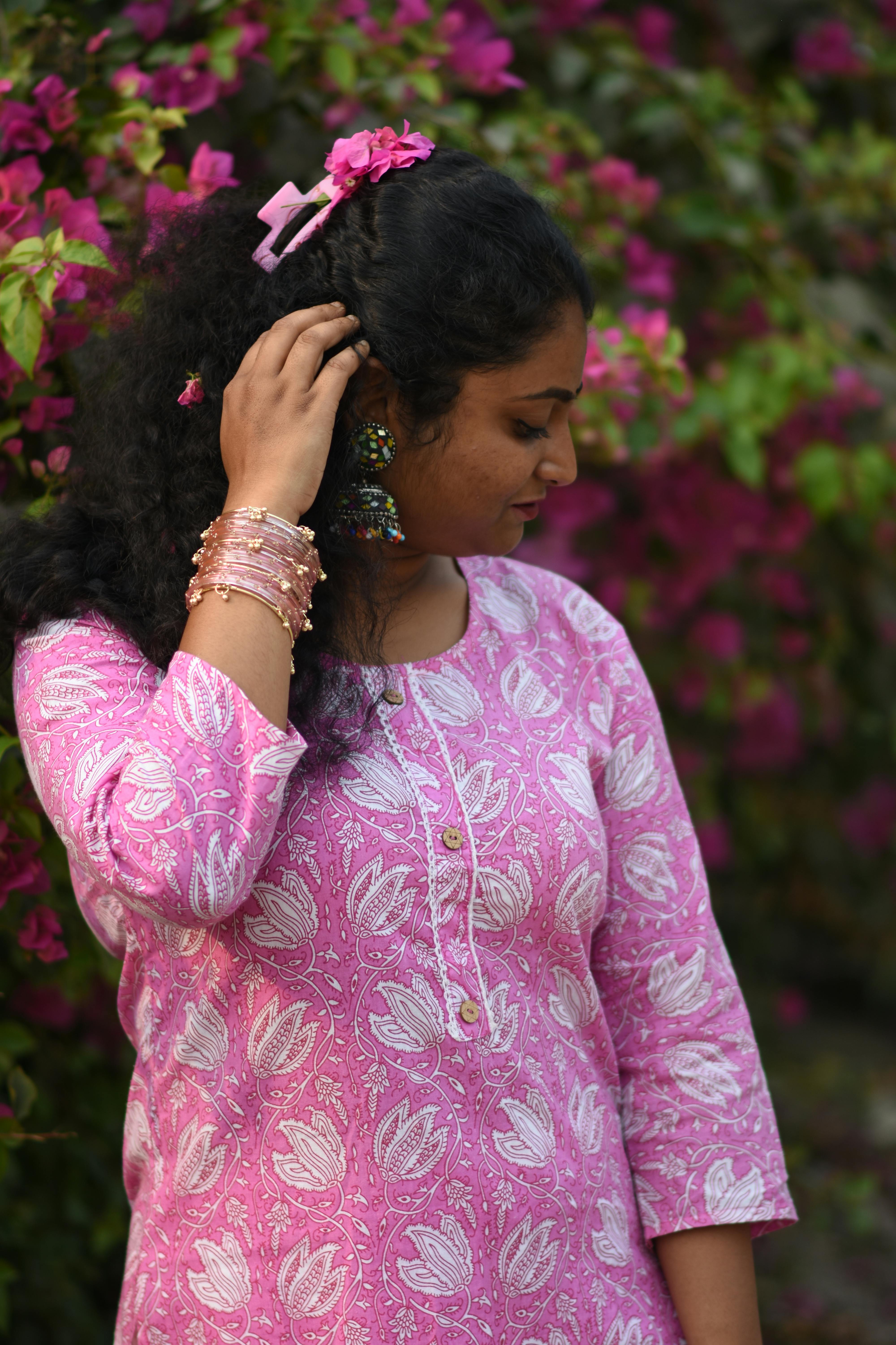 Kostenlos Südasiatische Frau in rosafarbener Tracht inmitten blühender Blumen in Kolkata, Indien. Stock-Foto
