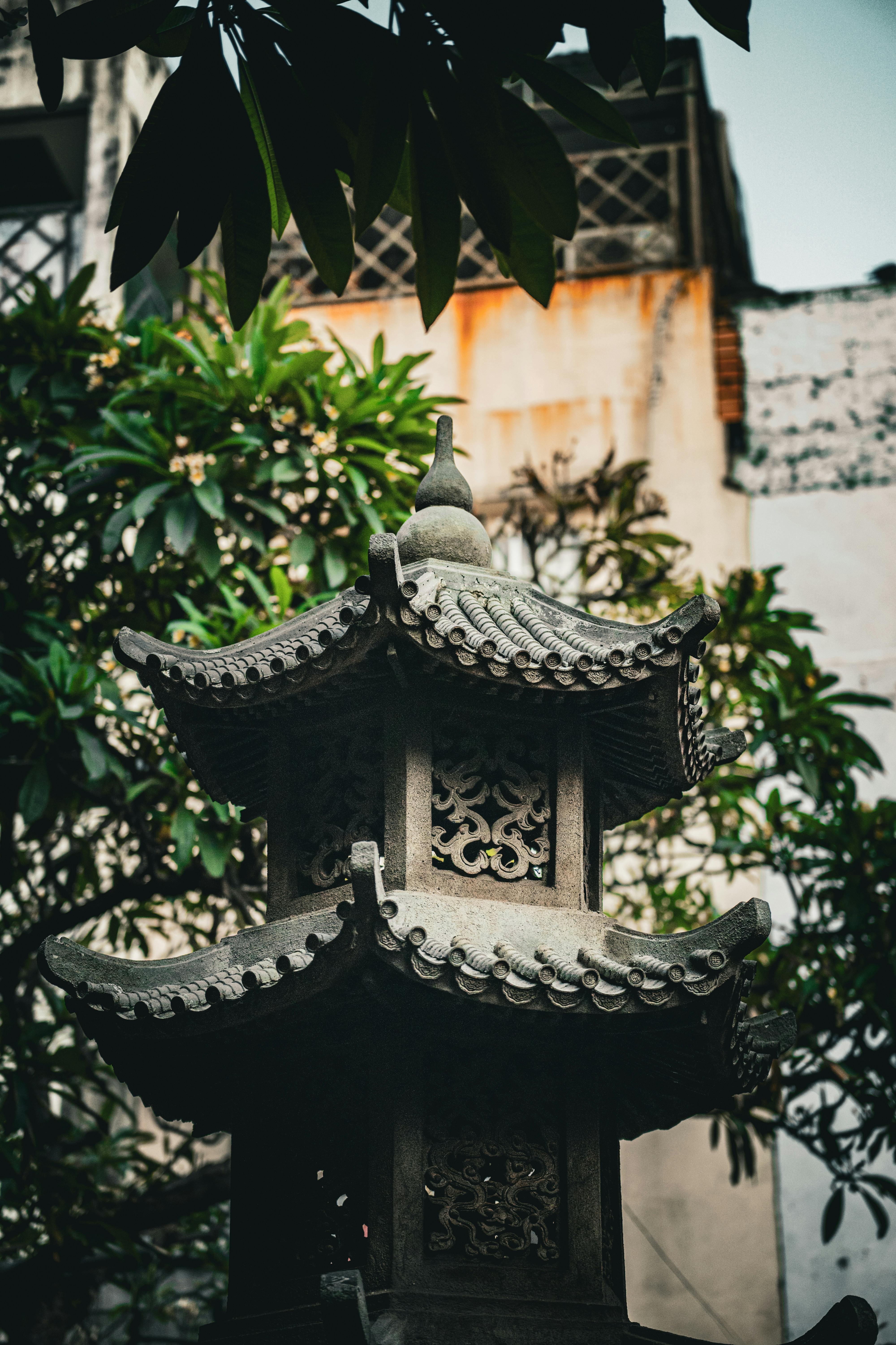 Δωρεάν Ένα διακοσμητικό πέτρινο φανάρι σε στιλ παγόδας σε έναν καταπράσινο κήπο, στην πόλη Χο Τσι Μινχ. Φωτογραφία από στοκ φωτογραφιών