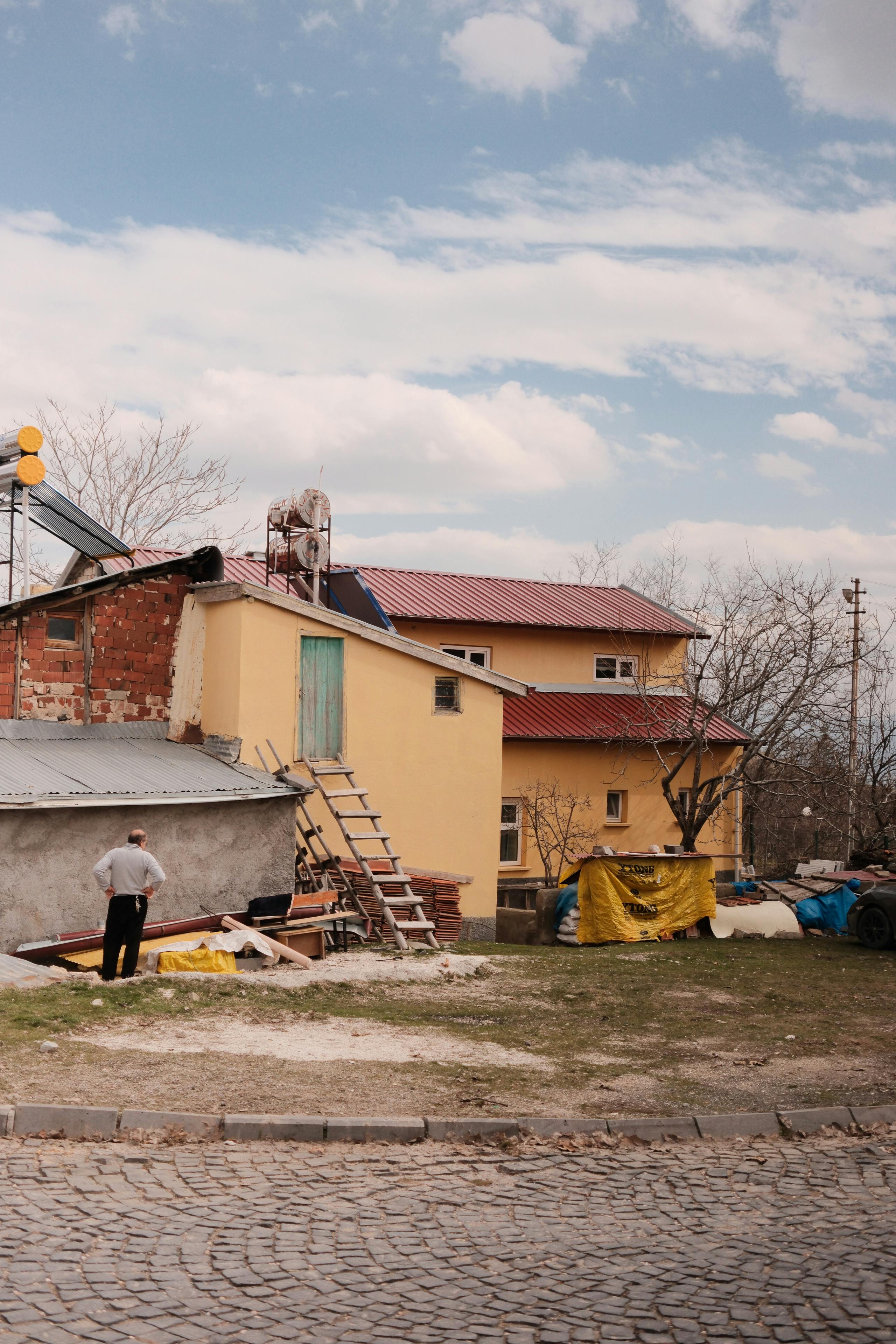 Δωρεάν Γοητευτική αγροτική σκηνή με κίτρινα σπίτια, λιθόστρωτα και ρουστίκ λεπτομέρειες. Φωτογραφία από στοκ φωτογραφιών