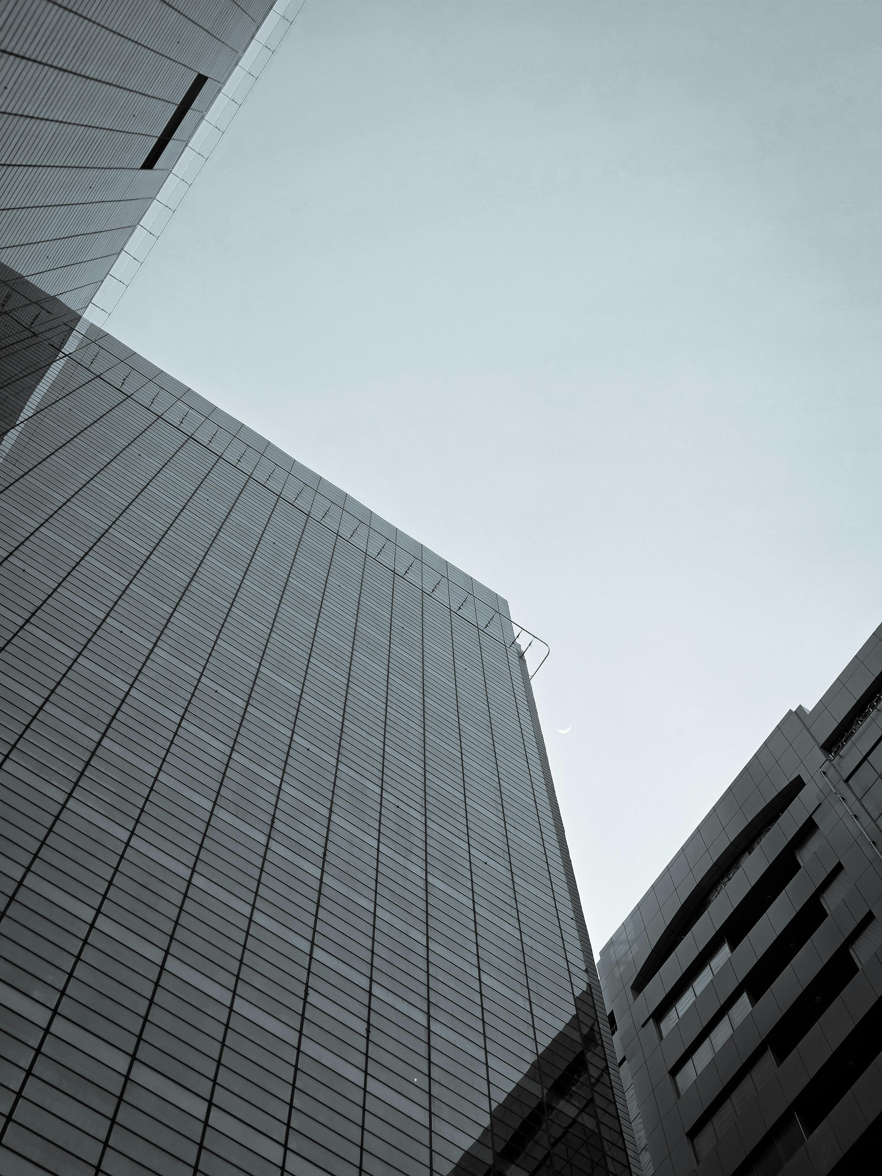 Free Low-angle view of modern skyscrapers with a clear sky backdrop. Stock Photo