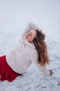 A woman in a cozy sweater and red skirt enjoying a winter day on the snow.