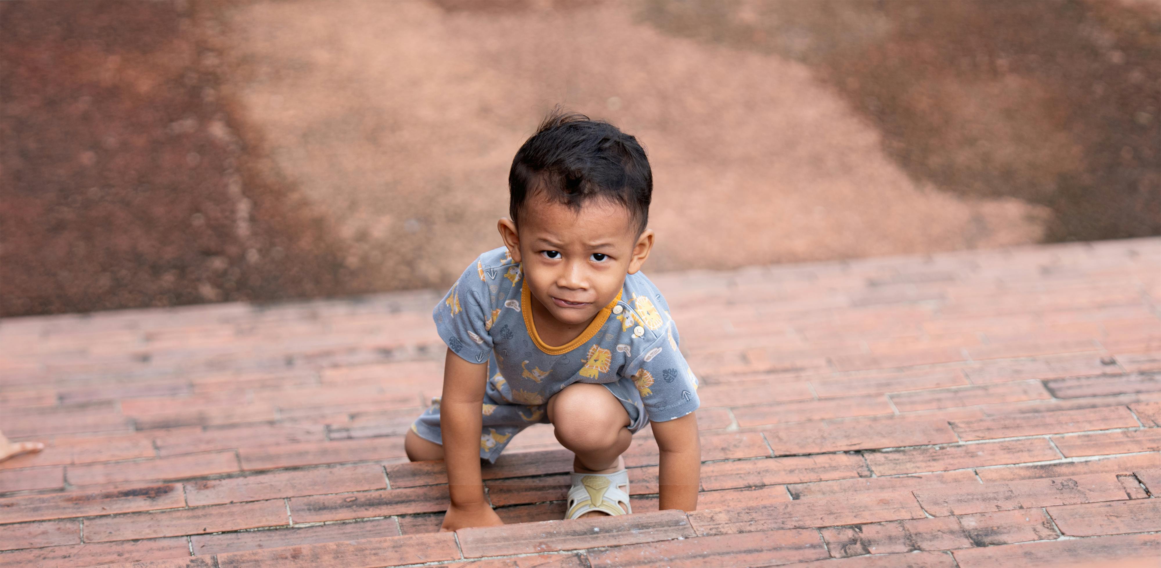 無料 好奇心と決意を示しながら、屋外でレンガの階段を登る少年。 写真素材