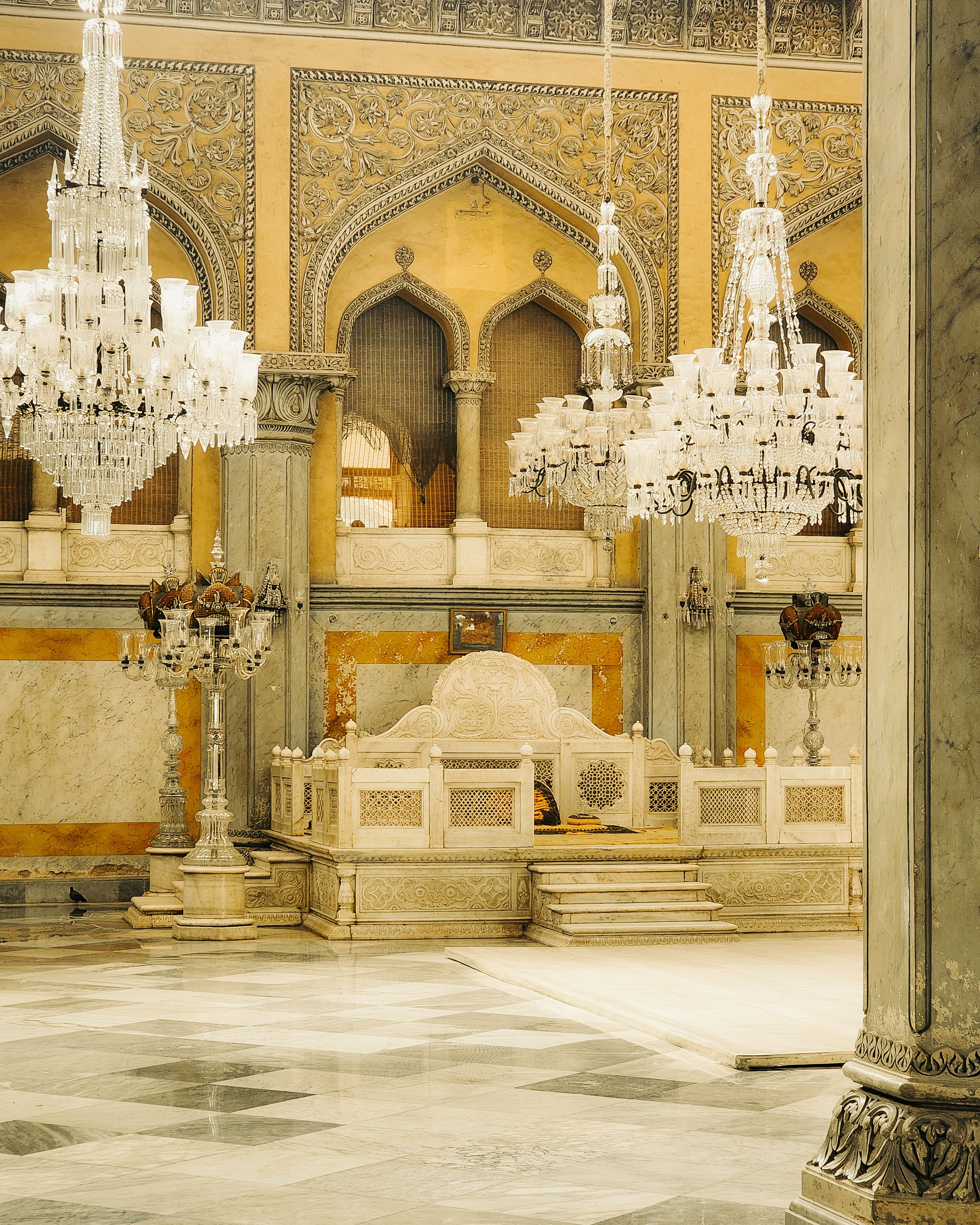 Elegant interior of an Indian palace featuring grand chandeliers and intricate architectural details.