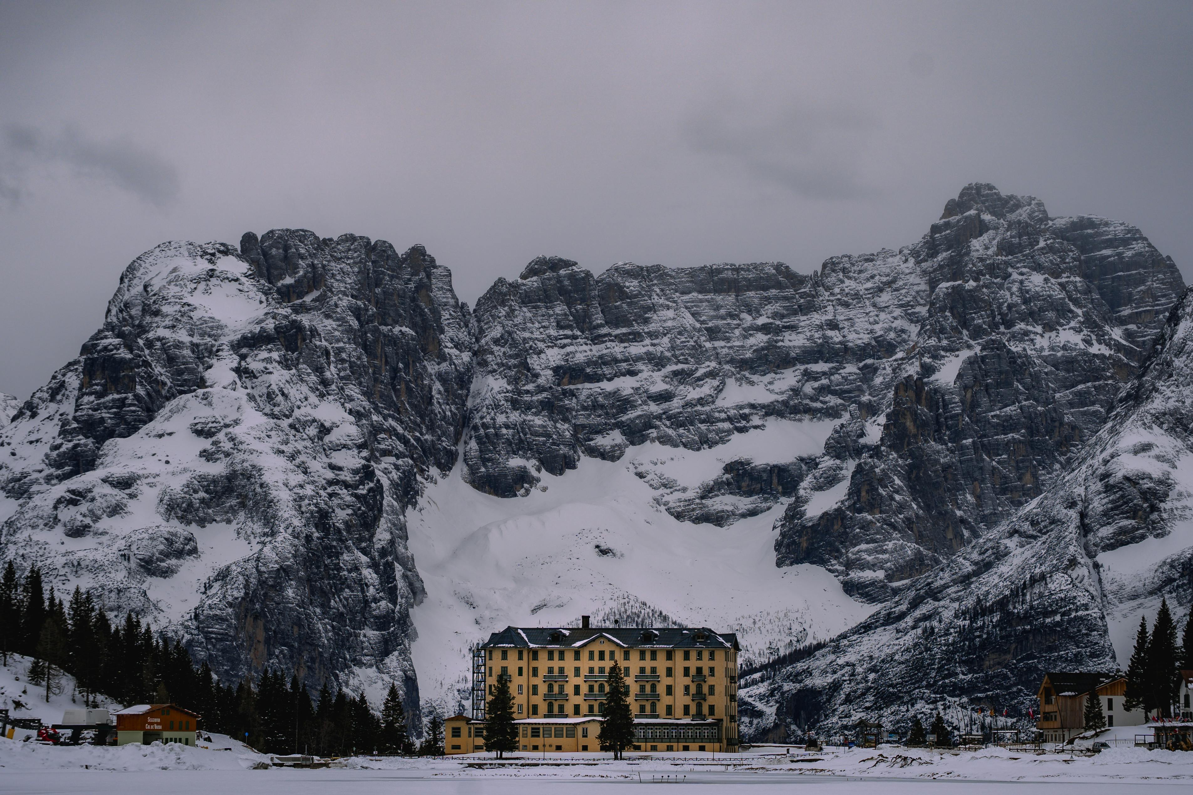 Δωρεάν Γραφική θέα ενός μεγάλου ξενοδοχείου ανάμεσα στους χιονισμένους Δολομίτες τον χειμώνα. Φωτογραφία από στοκ φωτογραφιών