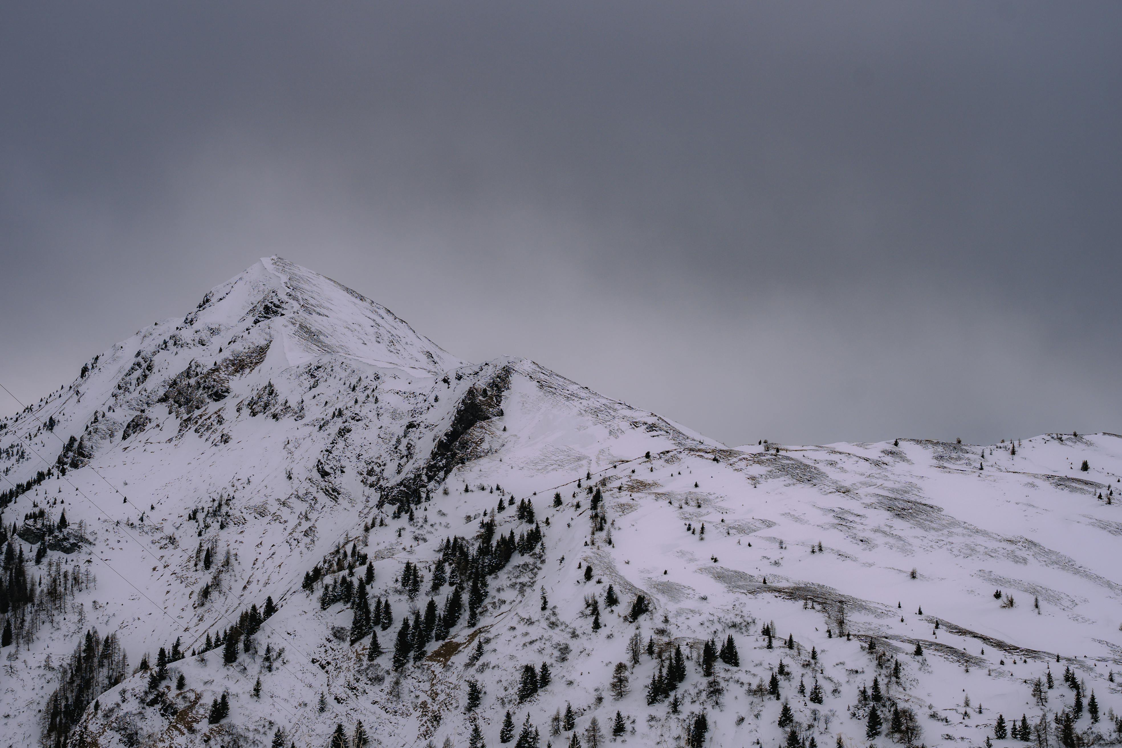 Δωρεάν Σαγηνευτική θέα μιας χιονισμένης βουνοκορφής που περιβάλλεται από έναν συννεφιασμένο ουρανό τον χειμώνα. Φωτογραφία από στοκ φωτογραφιών