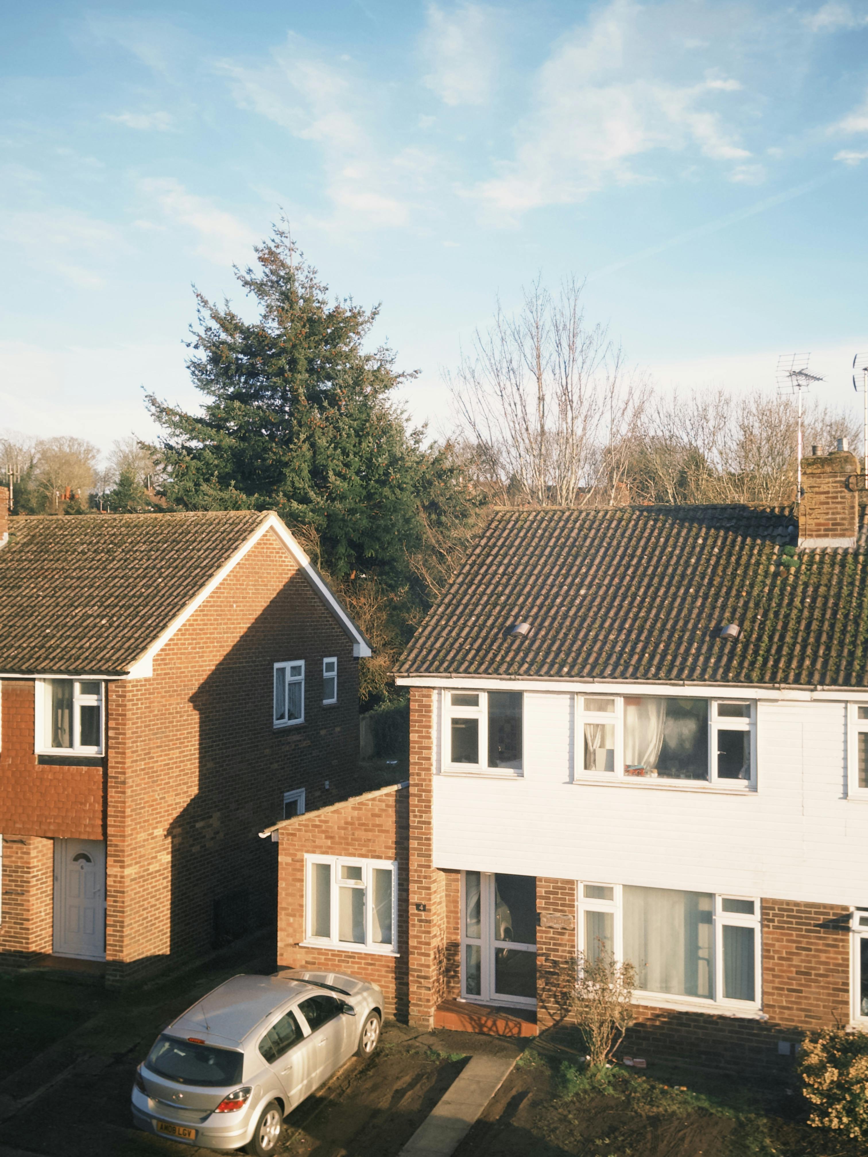 Kostenlos Charmante Vorstadthäuser mit Autos in einer ruhigen Wohngegend von Canterbury, eingefangen im Tageslicht. Stock-Foto