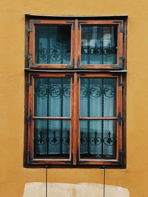 Free Charming vintage window with wrought iron design in Sighișoara, Romania. Stock Photo
