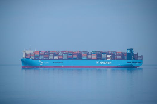 A Maersk container ship loaded with colorful cargo sailing on a serene sea.