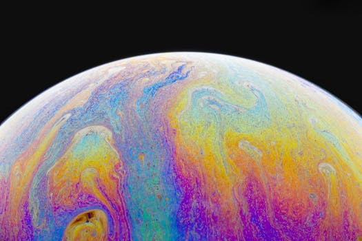 Colorful abstract sphere with vibrant iridescent patterns on a black background.