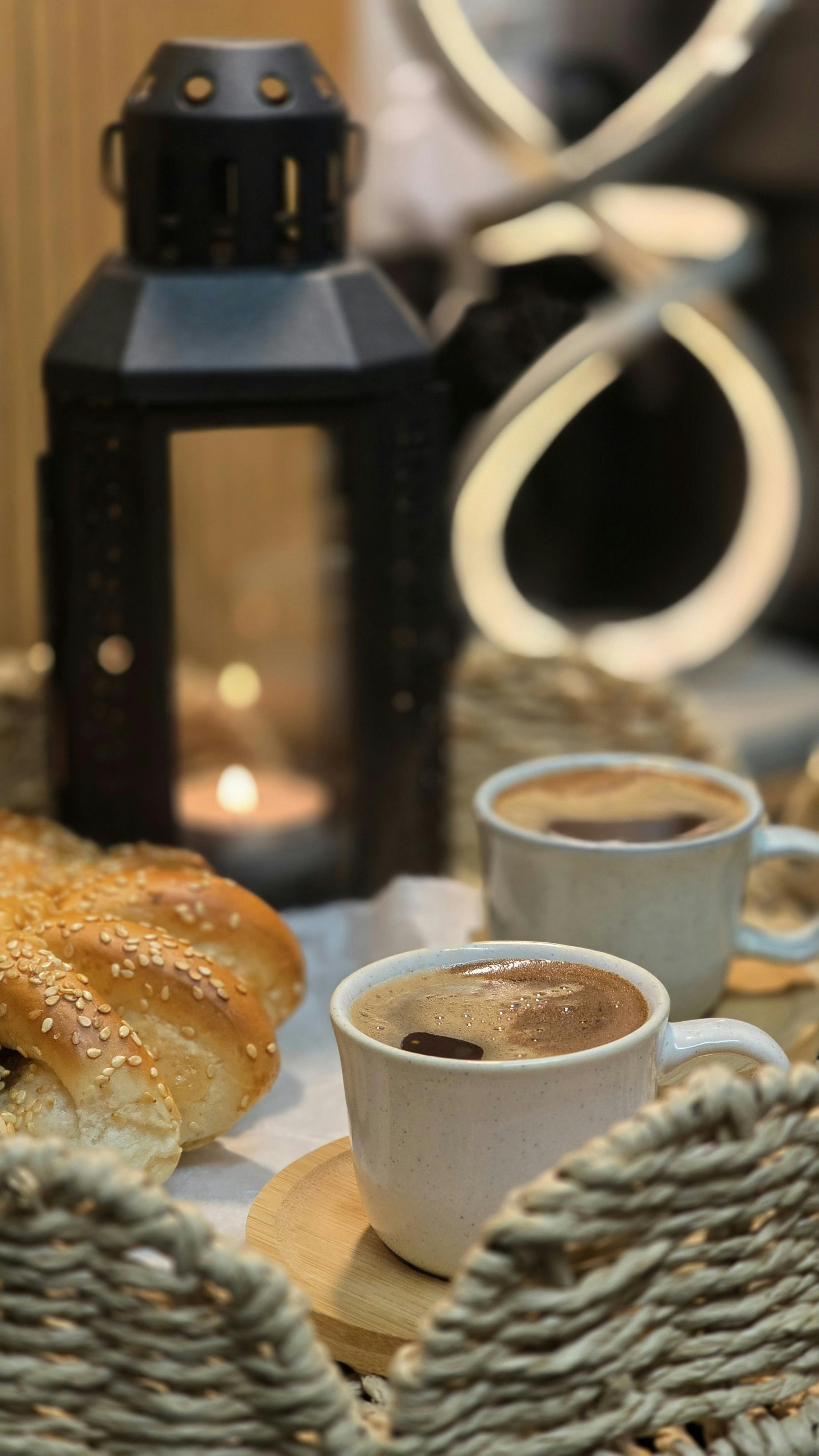 Kostenlos Warmer Kaffee mit Sesambrot im Kerzenlicht. Gemütliche Szene in Innenräumen. Stock-Foto