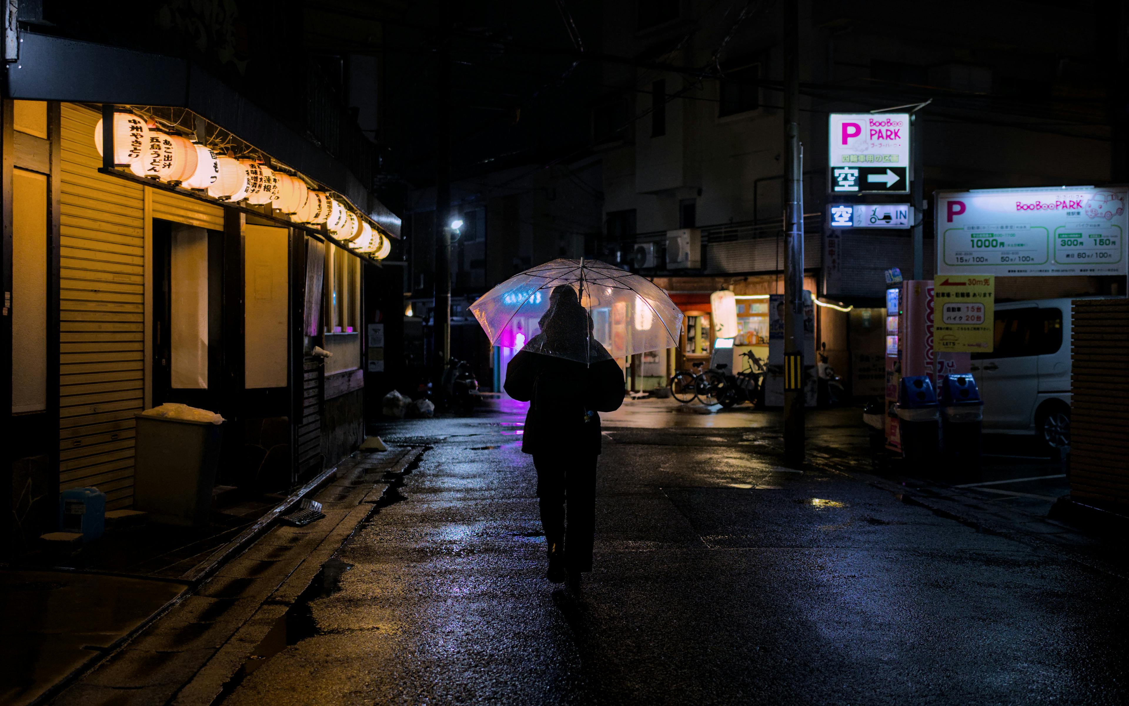 Δωρεάν Ένα άτομο περπατάει με ομπρέλα μια βροχερή νύχτα στο Κιότο της Ιαπωνίας, κάτω από φανάρια. Φωτογραφία από στοκ φωτογραφιών