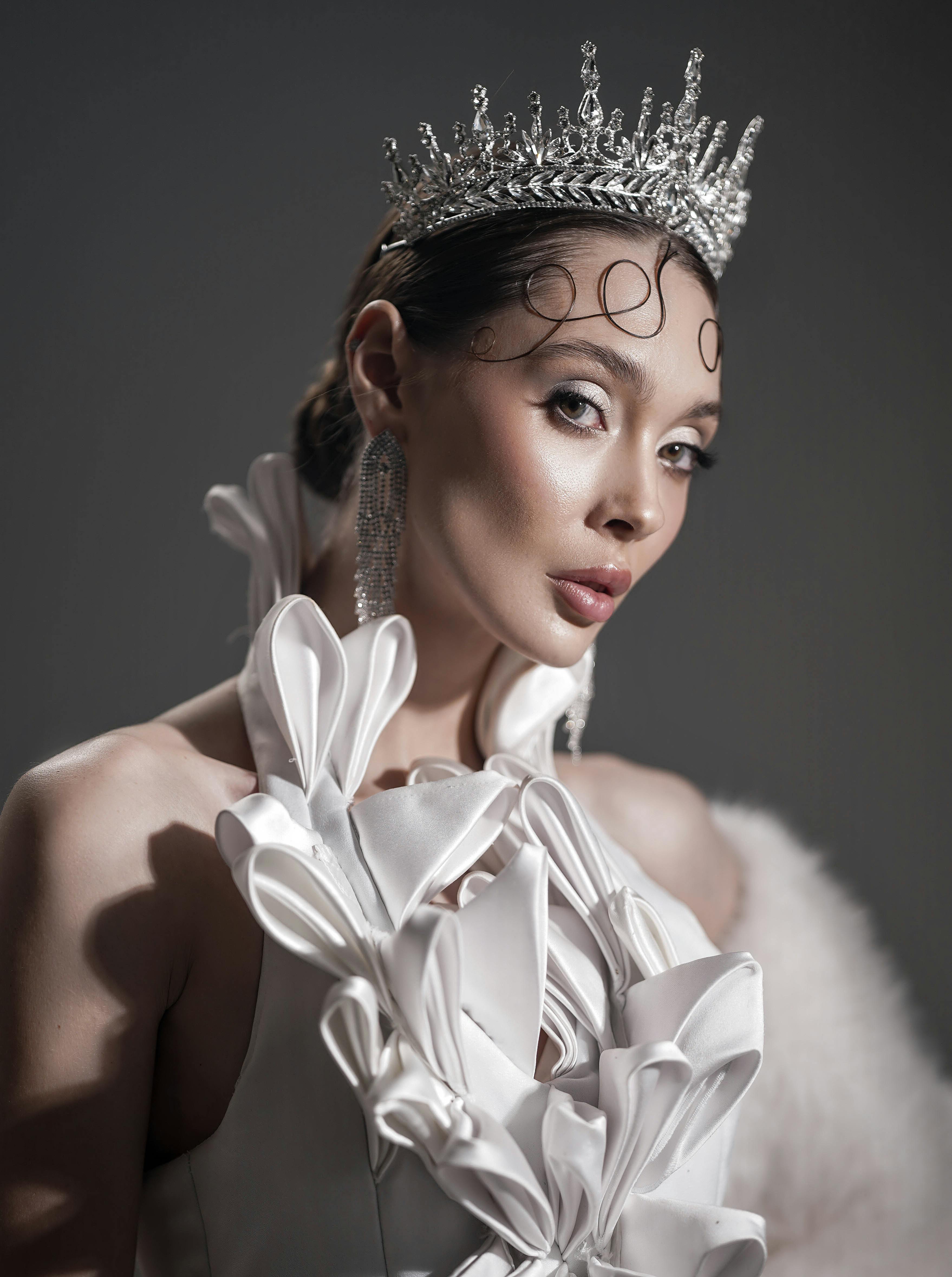 Kostenlos Ein atemberaubendes Porträt einer Frau in einem kunstvollen Diadem und weißem Kleid, die Eleganz und Anmut verkörpert. Stock-Foto