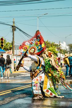 Dancer in colorful costume performing at Huejotzingo festival, Mexico.