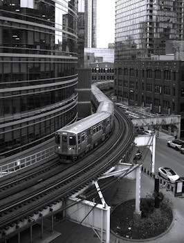 一张黑白照片，拍摄的是一辆芝加哥L线列车在伊利诺伊州芝加哥市中心转弯的场景。 - 相关推荐