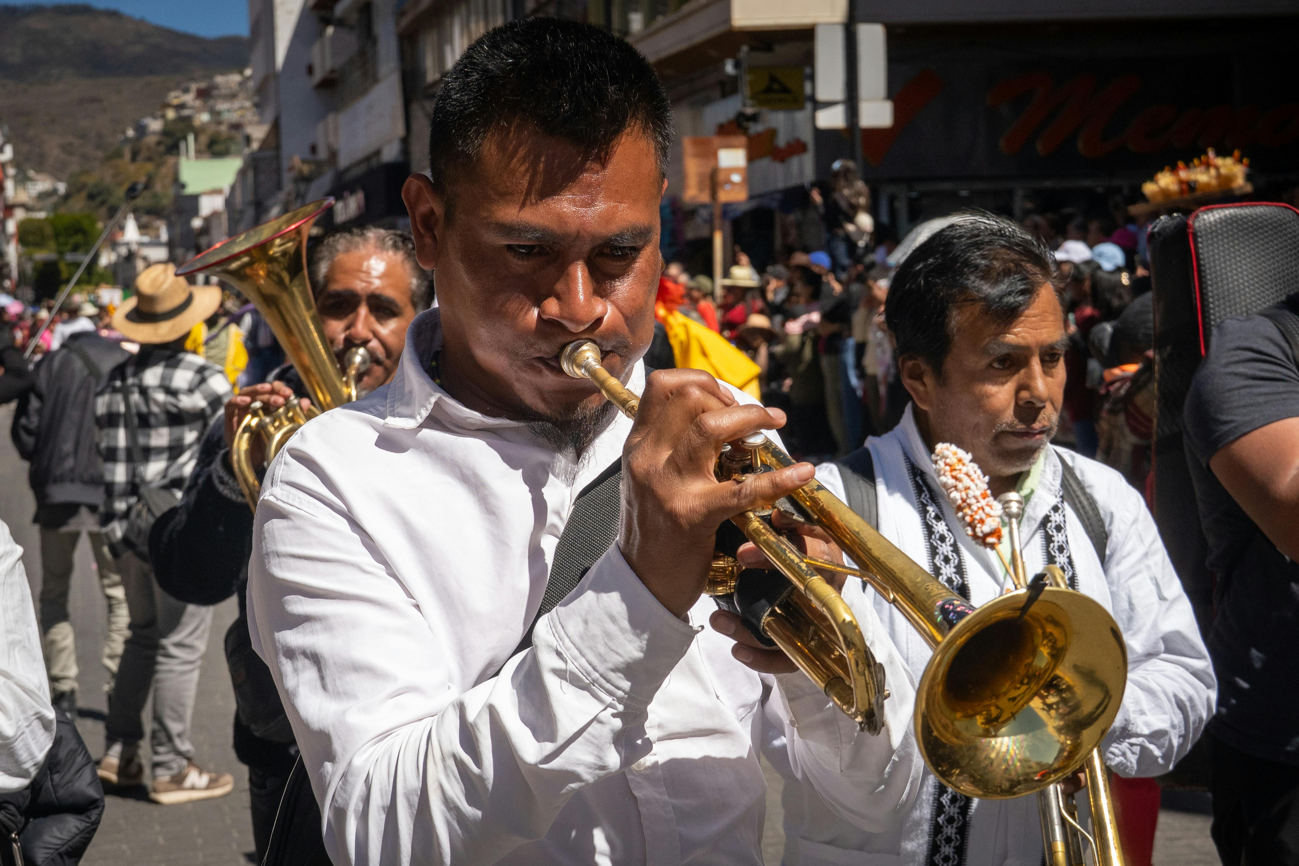 Kostenlos Eine lebhafte Straßenparade in Hidalgo, Mexiko, bei der Musiker Blechblasinstrumente spielen und das kulturelle Erbe feiern. Stock-Foto