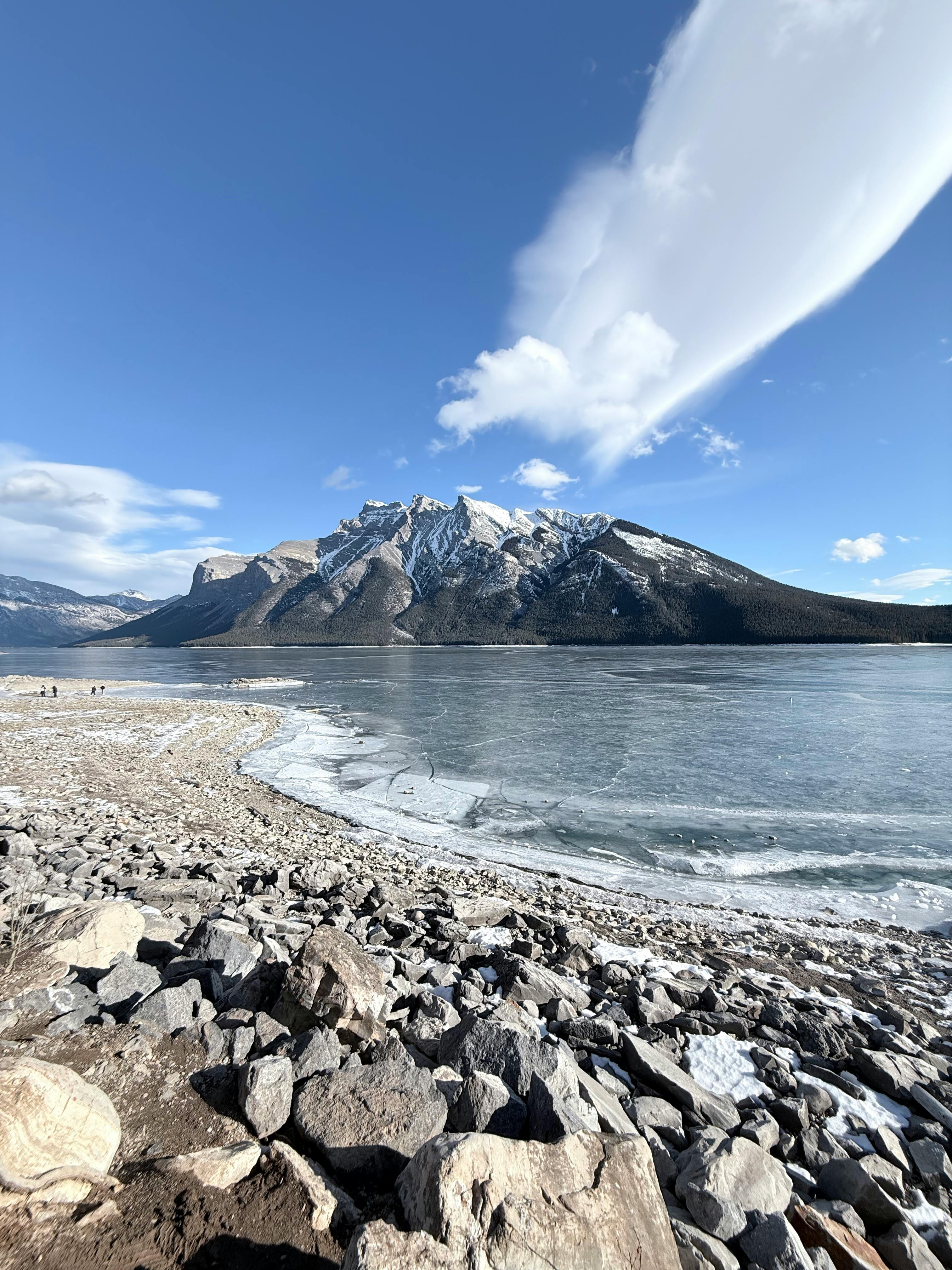 Kostenlos Eine atemberaubende Winterlandschaft mit einem zugefrorenen See und majestätischen, schneebedeckten Berggipfeln. Stock-Foto