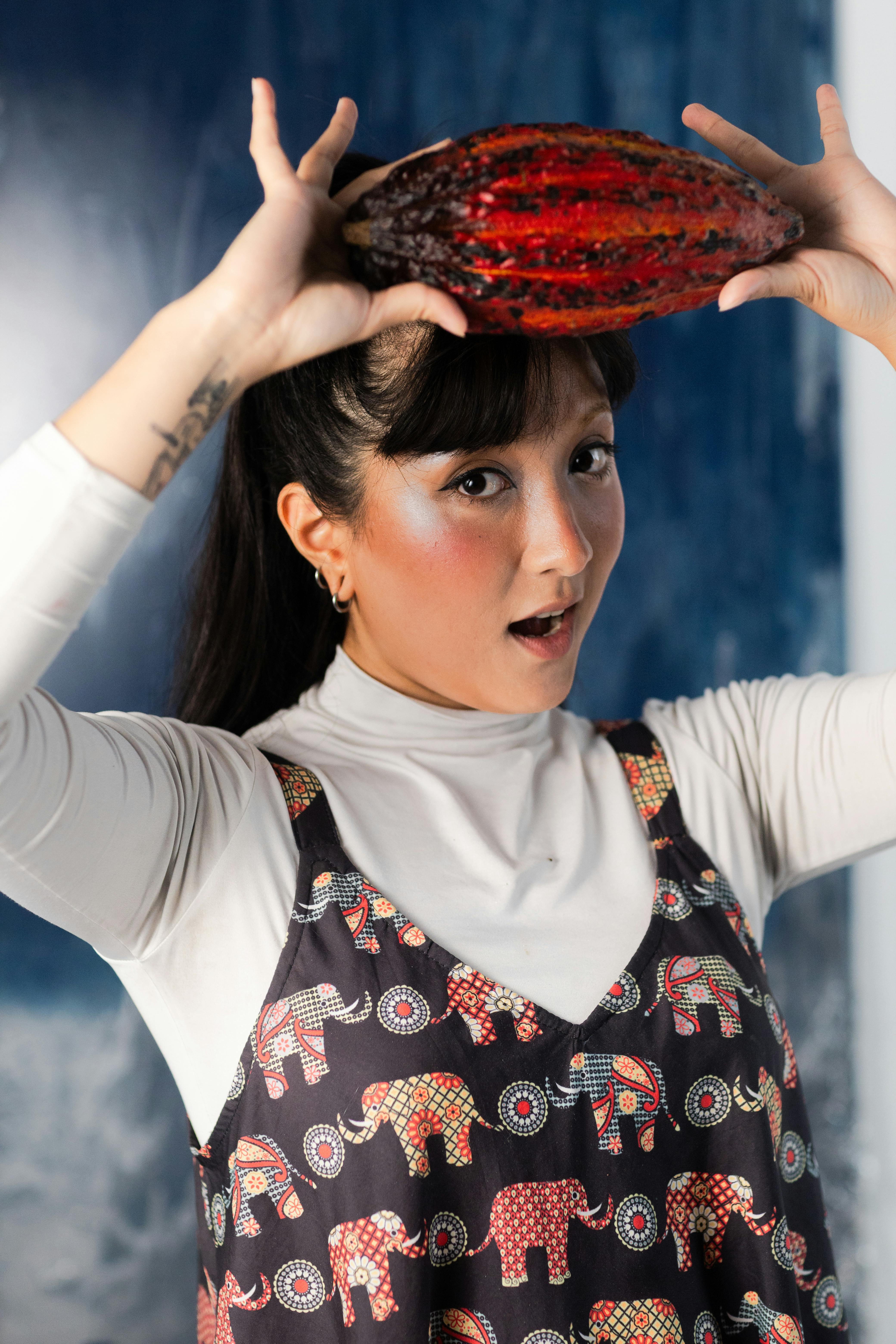 Gratis Ung kvinde poserer legende med en kakaokapsel over hovedet indendørs i São Paulo, Brasilien. Lagerfoto