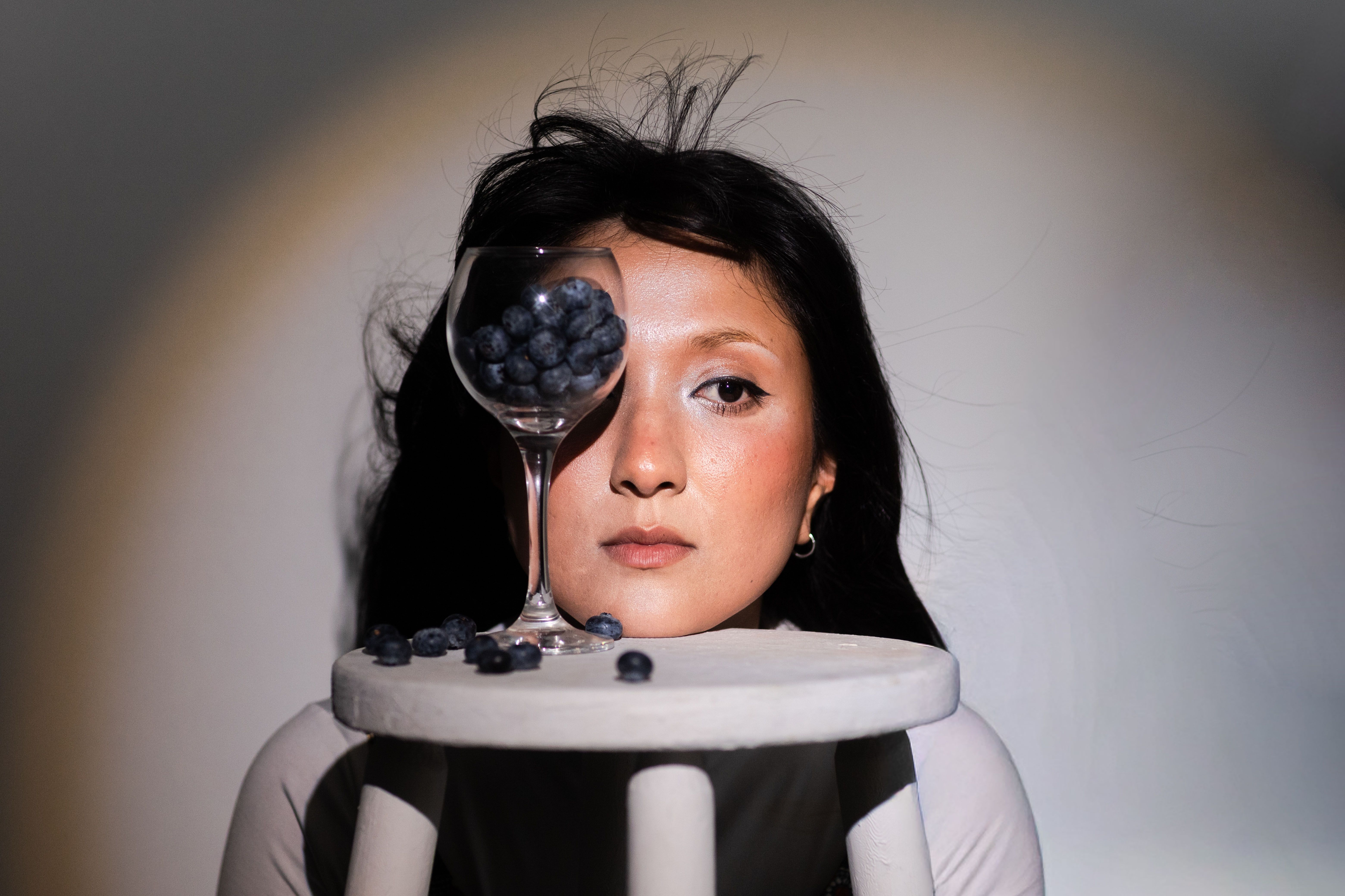 Creative portrait of a woman with blueberries and glass reflection, blending art and food for a unique visual effect. - Evidence evidence guide for blueberry visual performance randomized trial