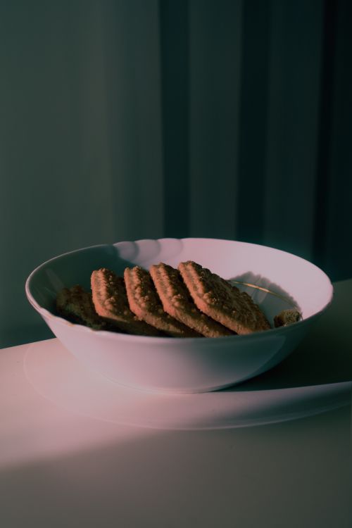 Free A serene bowl of biscuits with soft lighting, perfect for snack time. Stock Photo