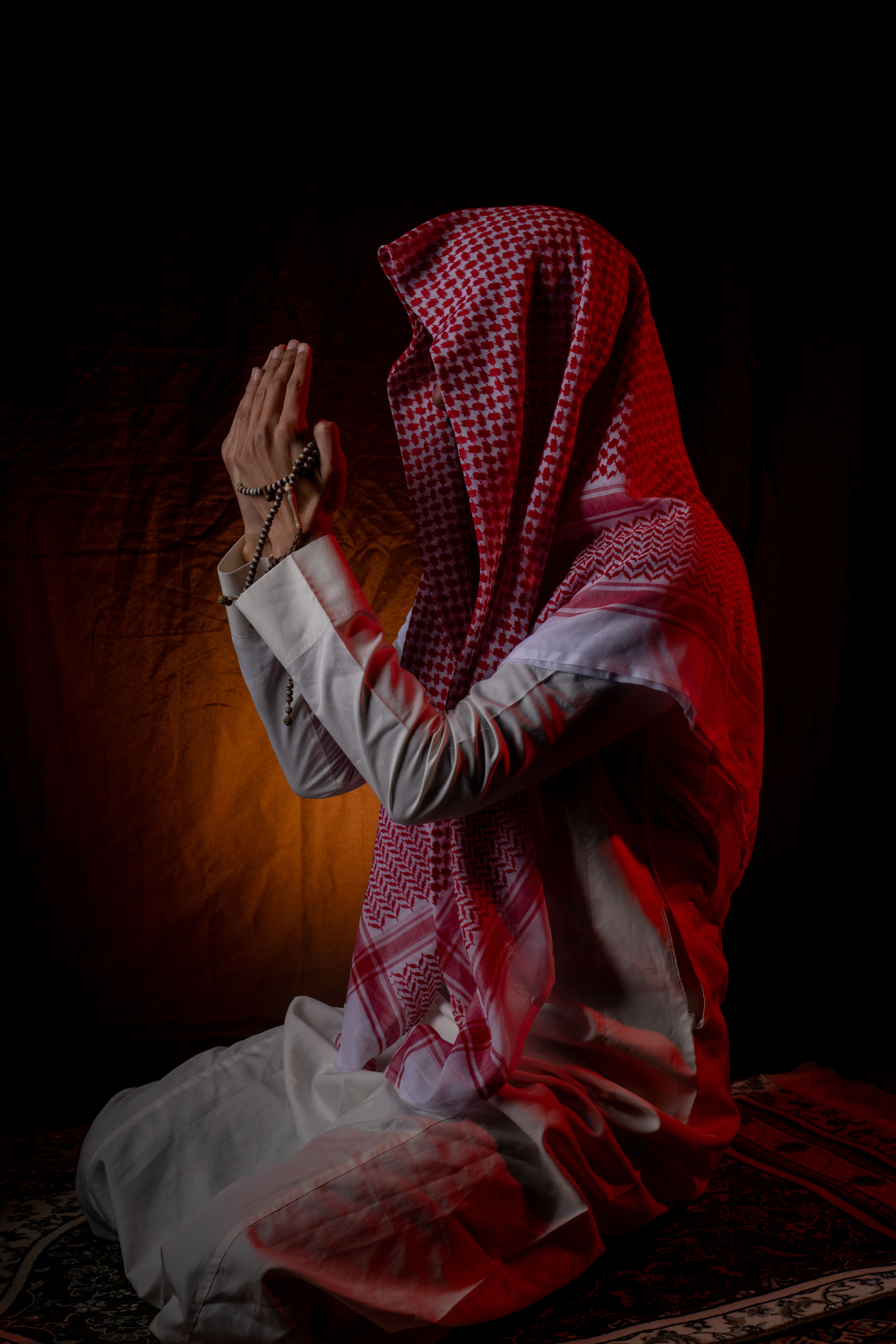 Man Praying with Prayer Beads in Traditional Attire · Free Stock Photo