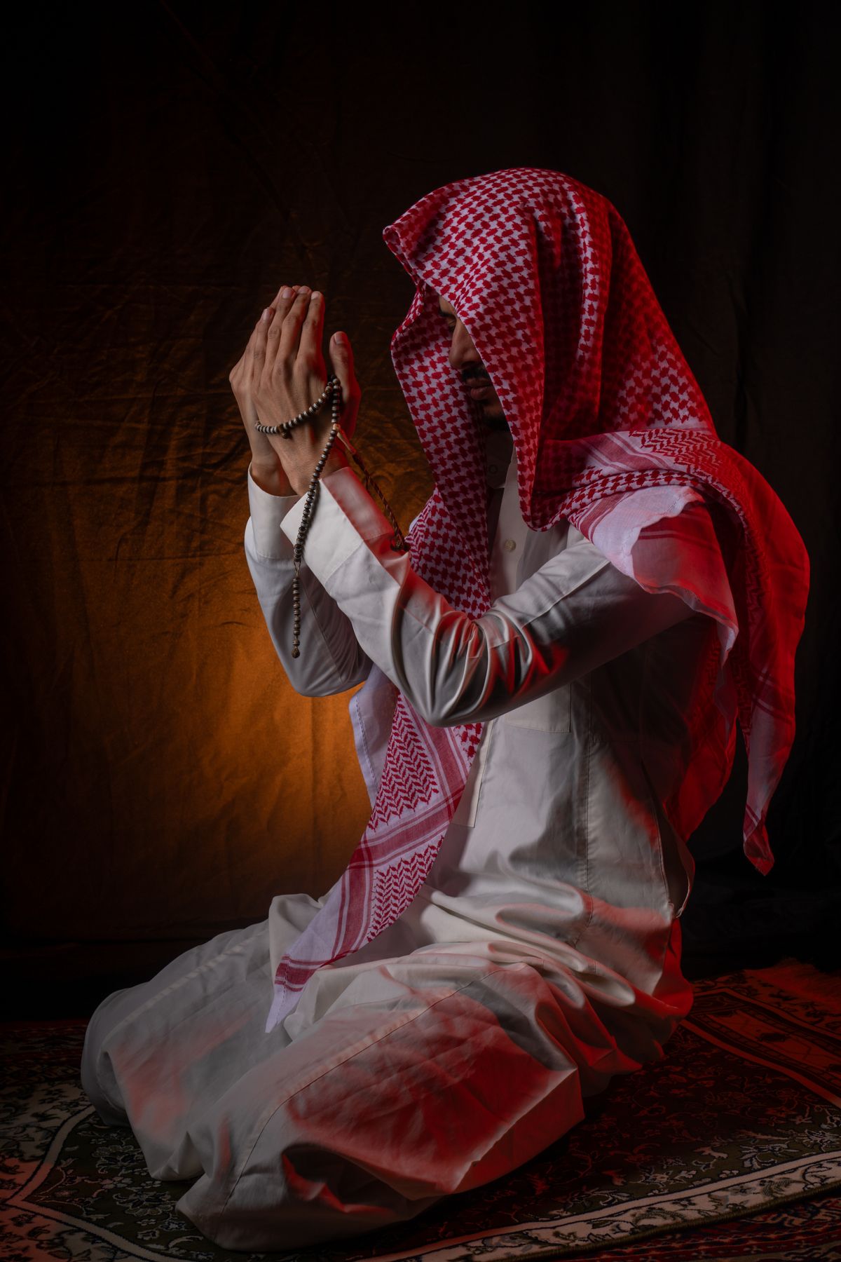 Man Praying with Rosary Beads in Traditional Attire · Free Stock Photo
