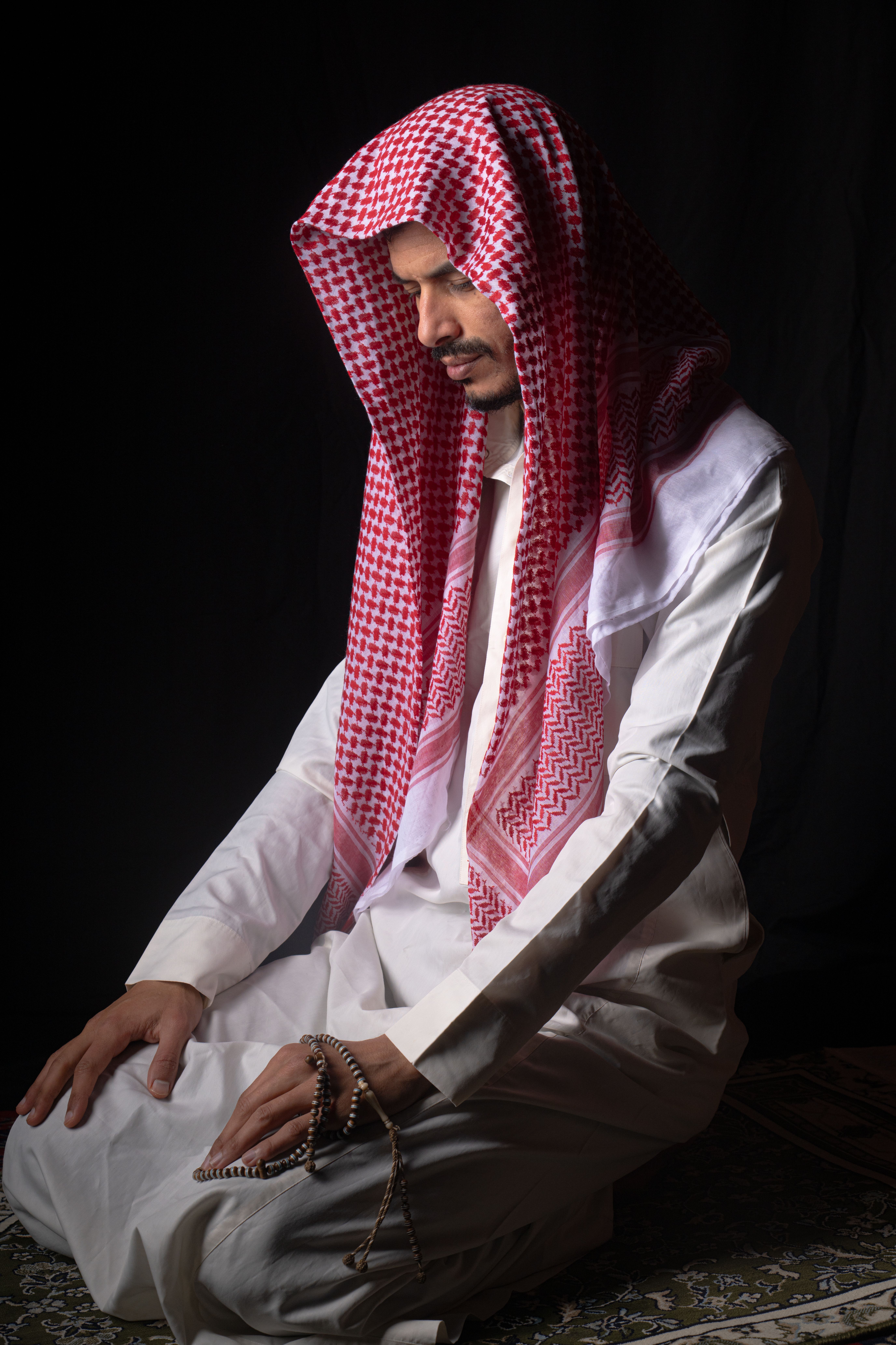 Arab Man Praying in Traditional Attire · Free Stock Photo