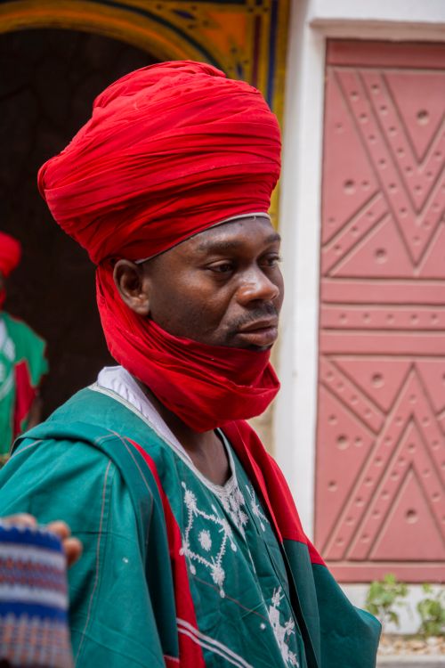 Free Man in vibrant traditional African clothing and turban during a cultural celebration outdoors. Stock Photo