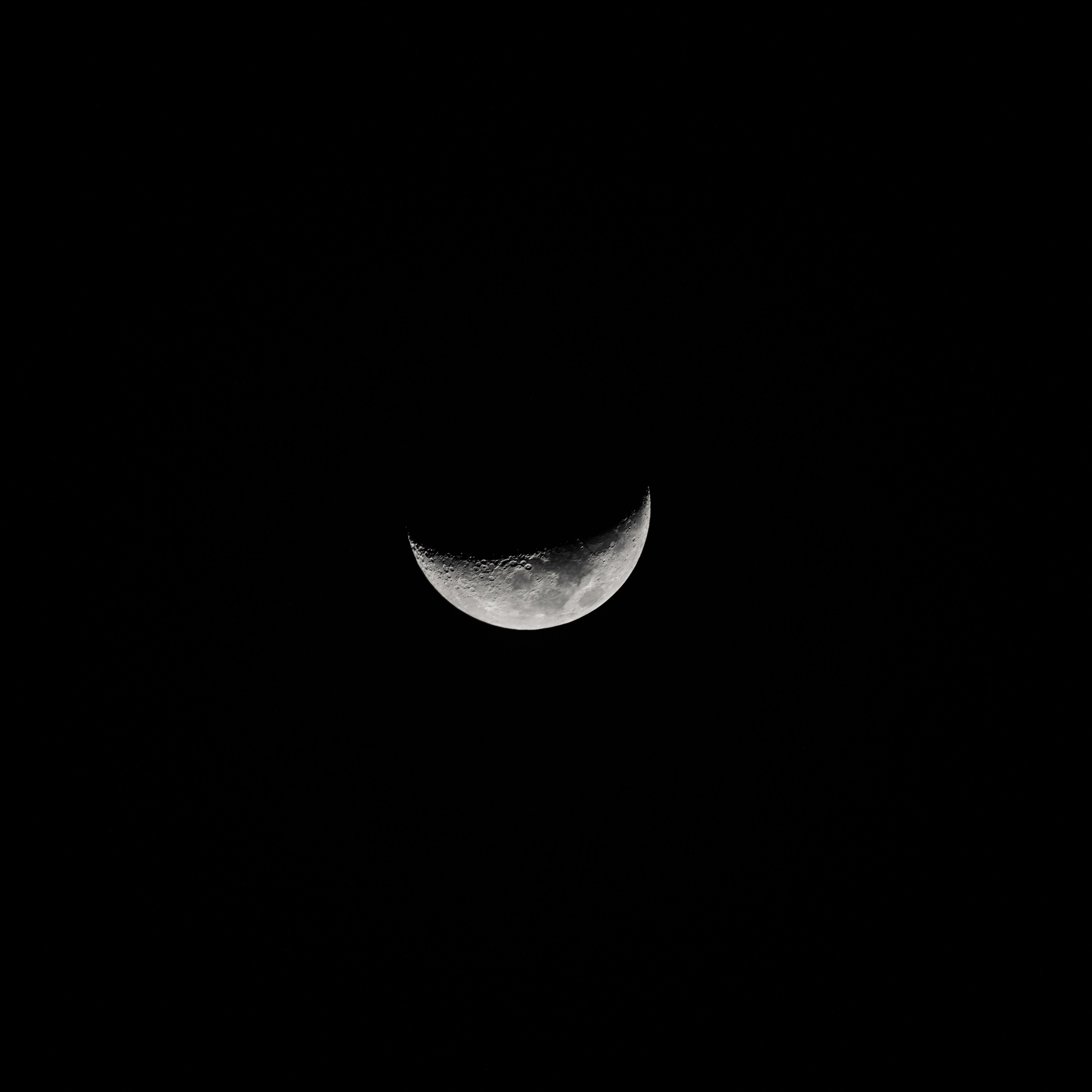 Stunning crescent moon against a pitch-black sky, showcasing lunar texture.