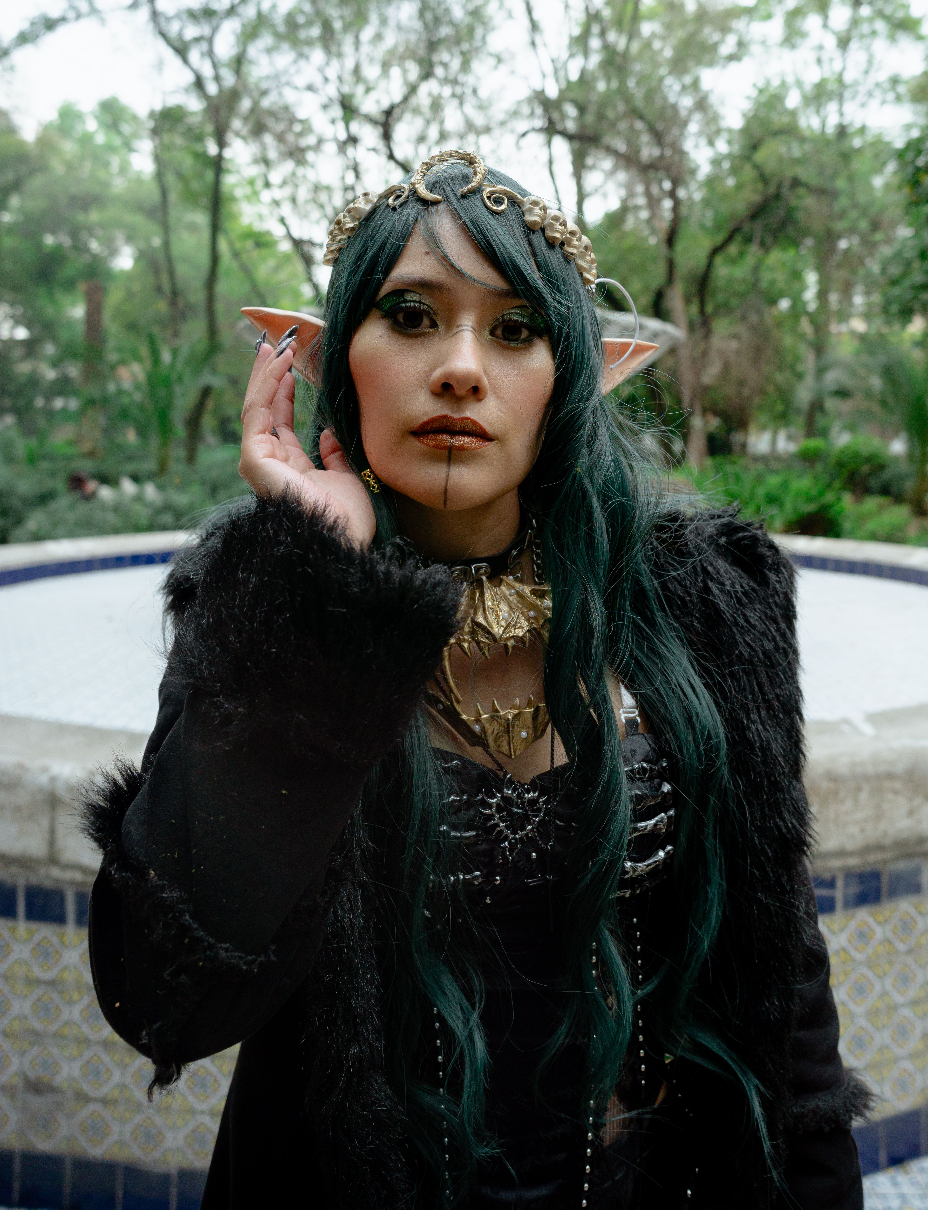 A captivating portrait of a female elf cosplayer in an outdoor setting, surrounded by nature.