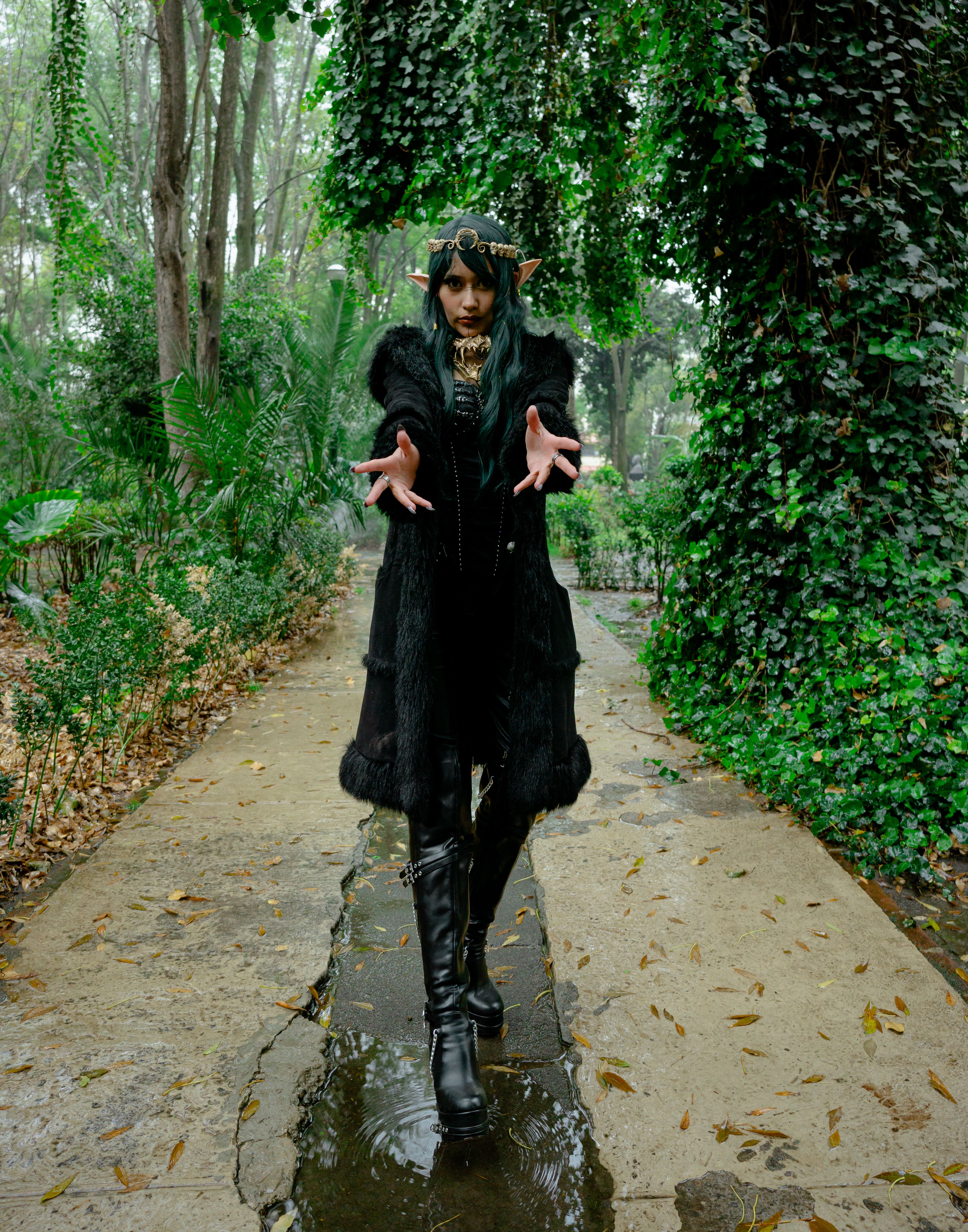 [ColoSach]-mysterious-elf-woman-in-gothic-attire-poses-in-lush-green-forest-setting.