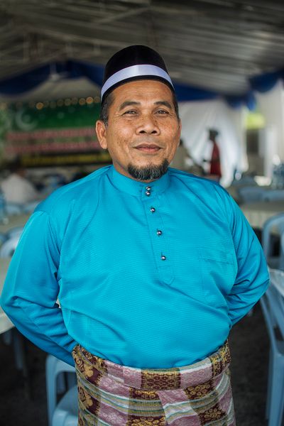 Ayah Melayu tersenyum memakai baju kemeja