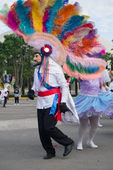 Colorful carnaval dancers parading in Tlaxcala, Mexico with traditional costumes and feather headdresses.