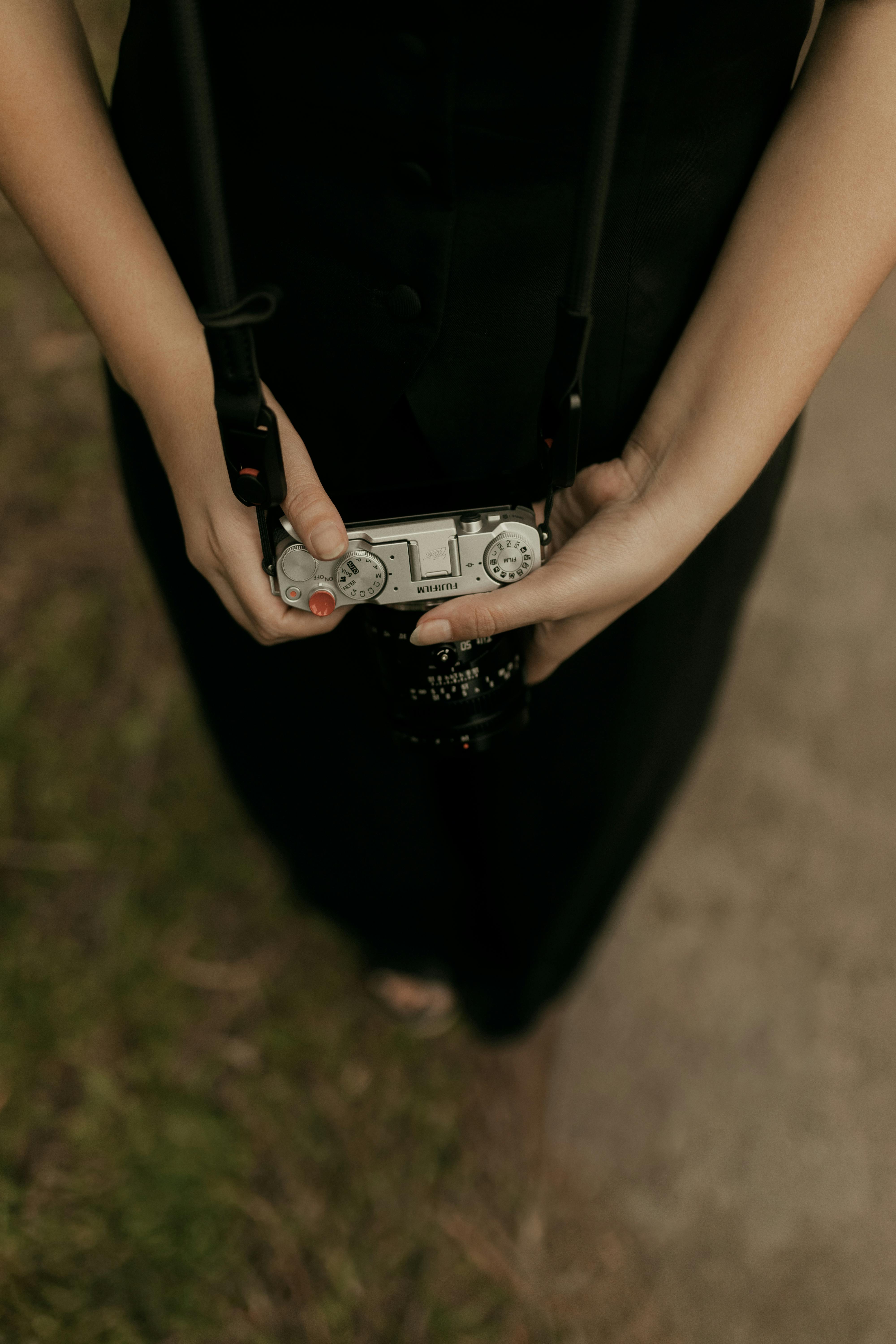 Ücretsiz Dış mekanda, askısıyla birlikte eski bir fotoğraf makinesini tutan ellerin yakın çekim görüntüsü. Stok Fotoğraflar