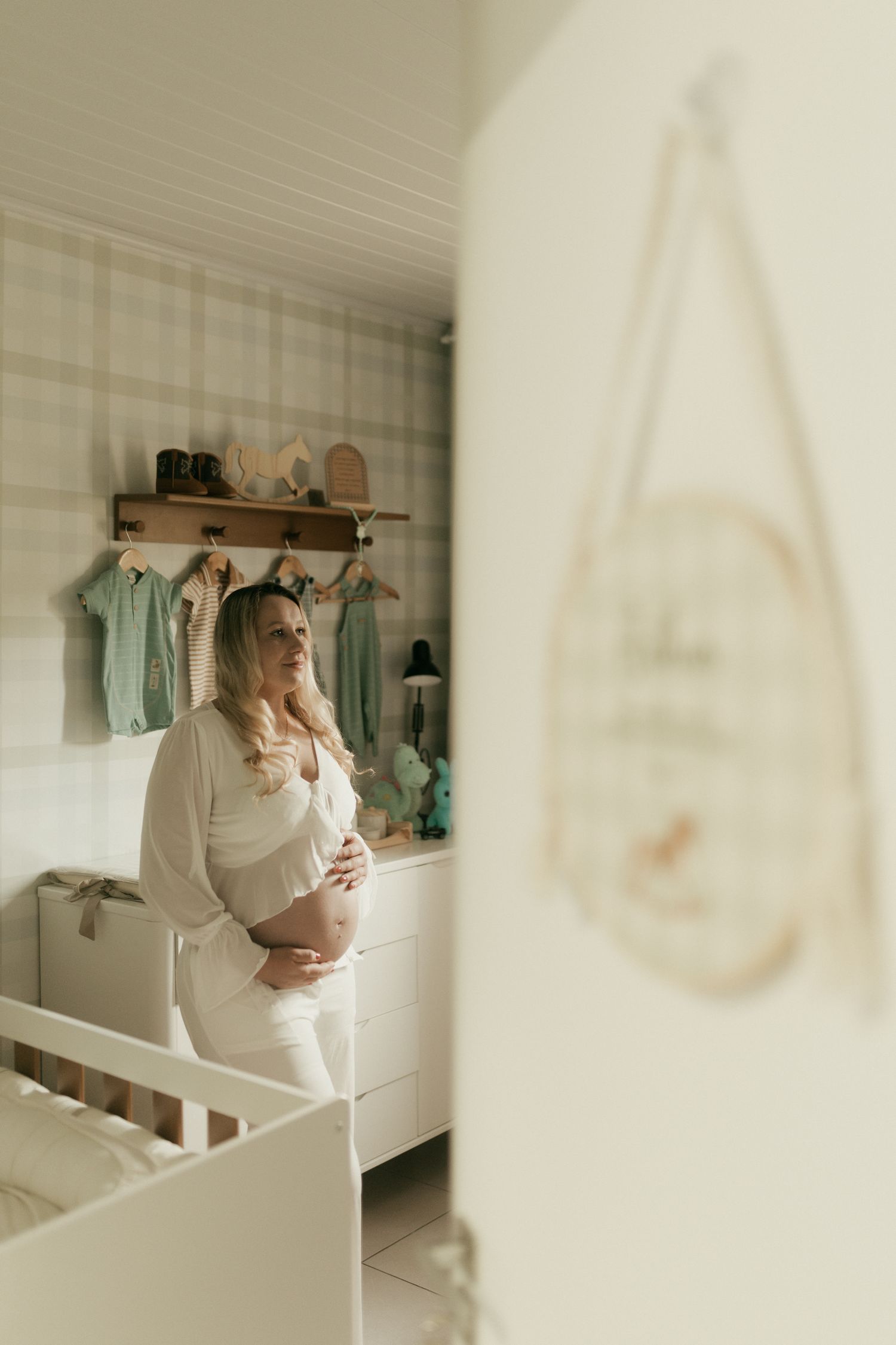 Future maman réfléchissant calmement dans une chambre de bébé lumineuse