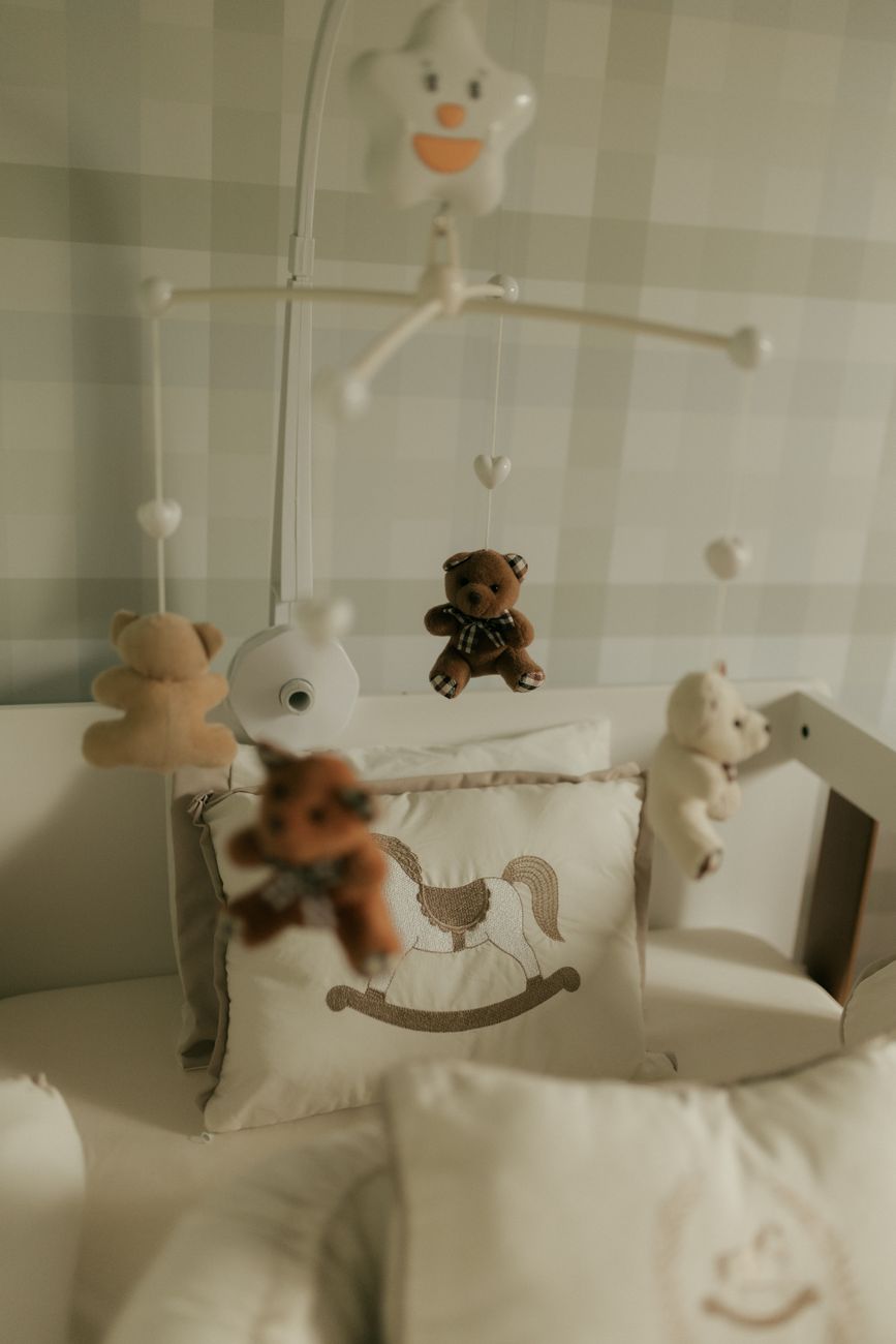Quarto de bebê tranquilo com móbile de ursinho de pelúcia acima do berço