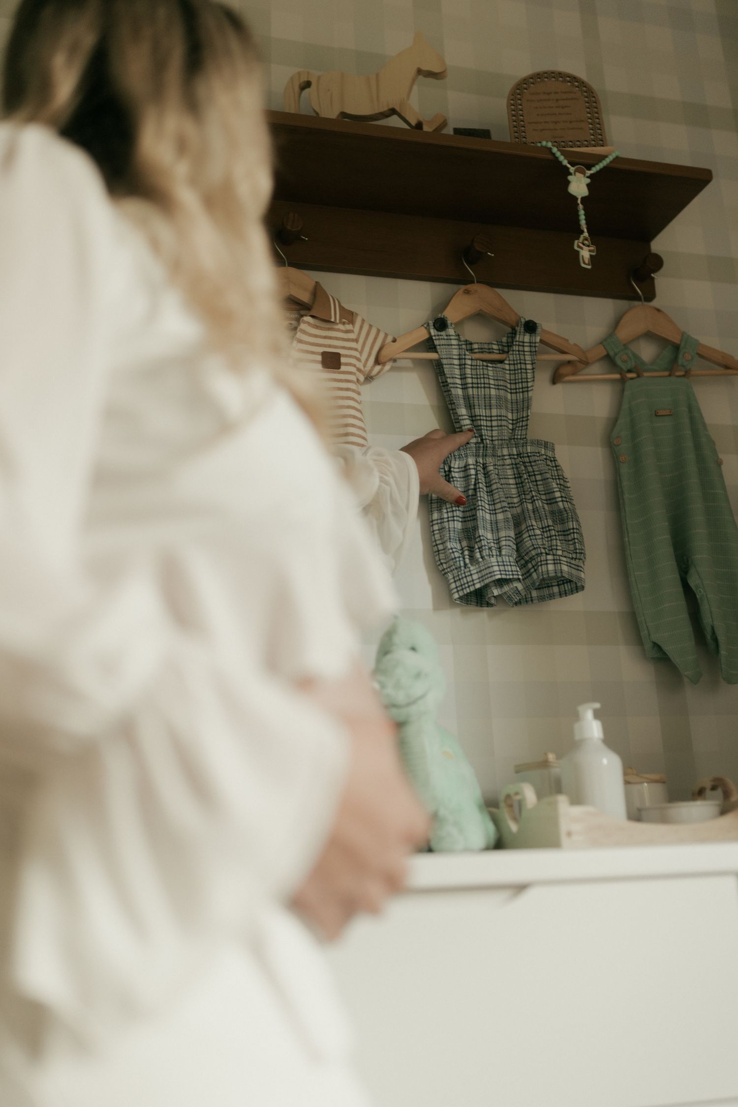 Femme enceinte choisissant les premiers vêtements de son bébé dans sa chambre