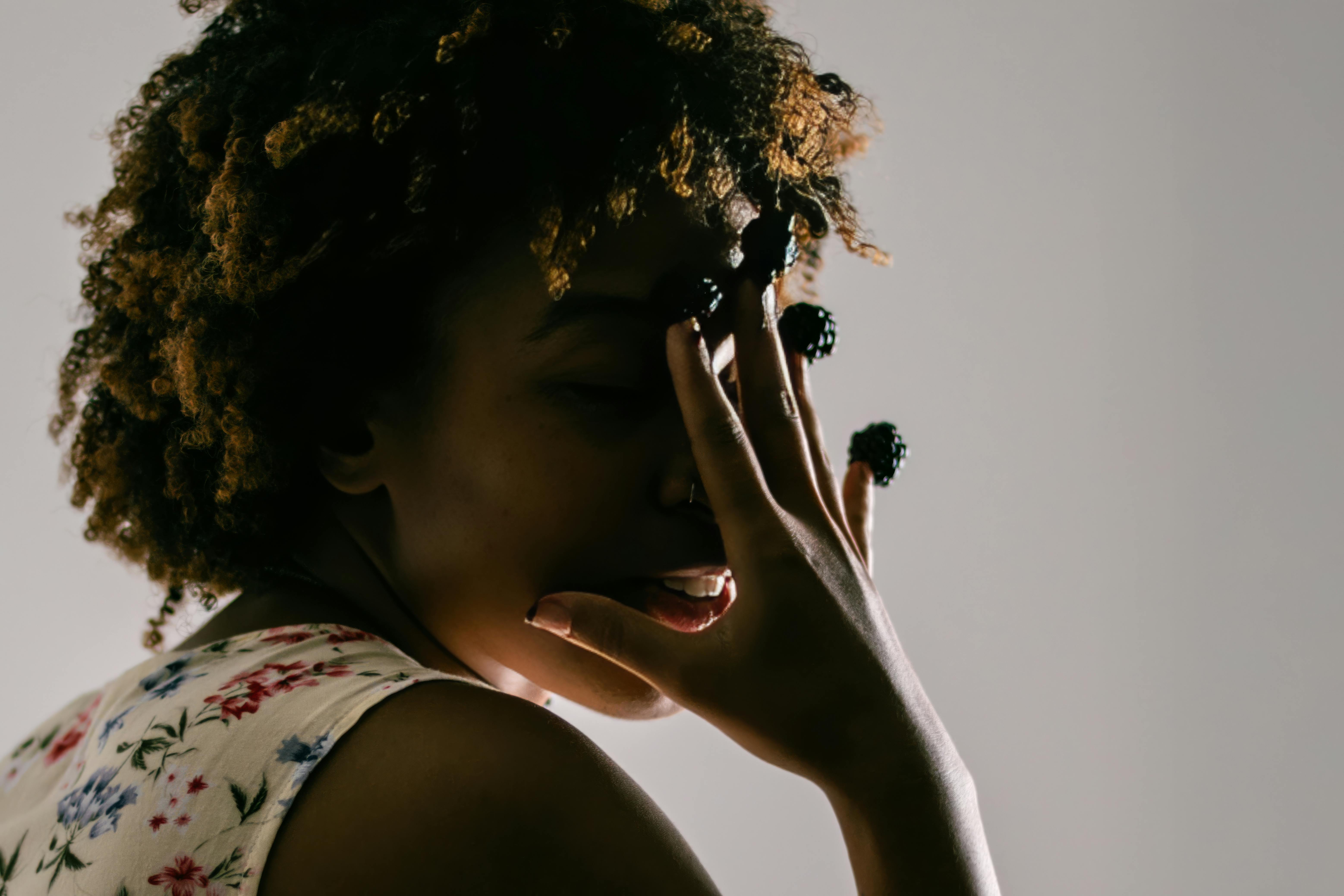 Free Creative side portrait of a woman holding blackberries against playful lighting. Stock Photo