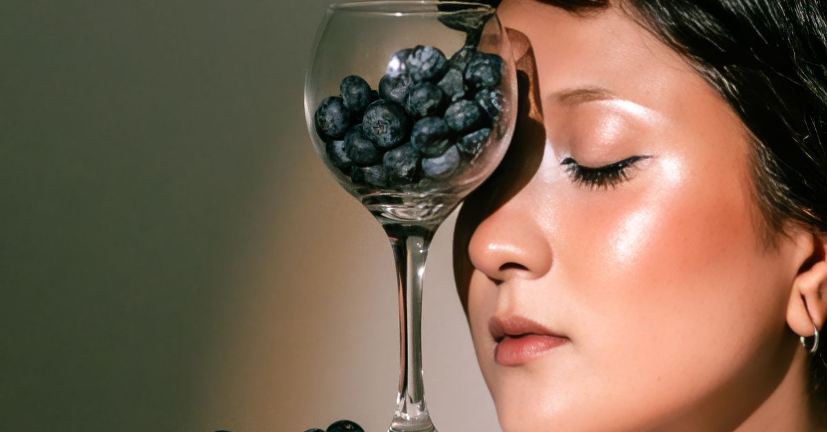 Close-up portrait of a woman alongside a glass filled with blueberries, capturing elegance and creativity. - Evidence evidence guide for blueberry-visual-fatigue-randomized-trial
