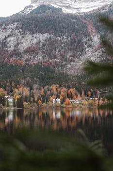 Tranquil autumn scene featuring a serene lake and majestic mountain view.