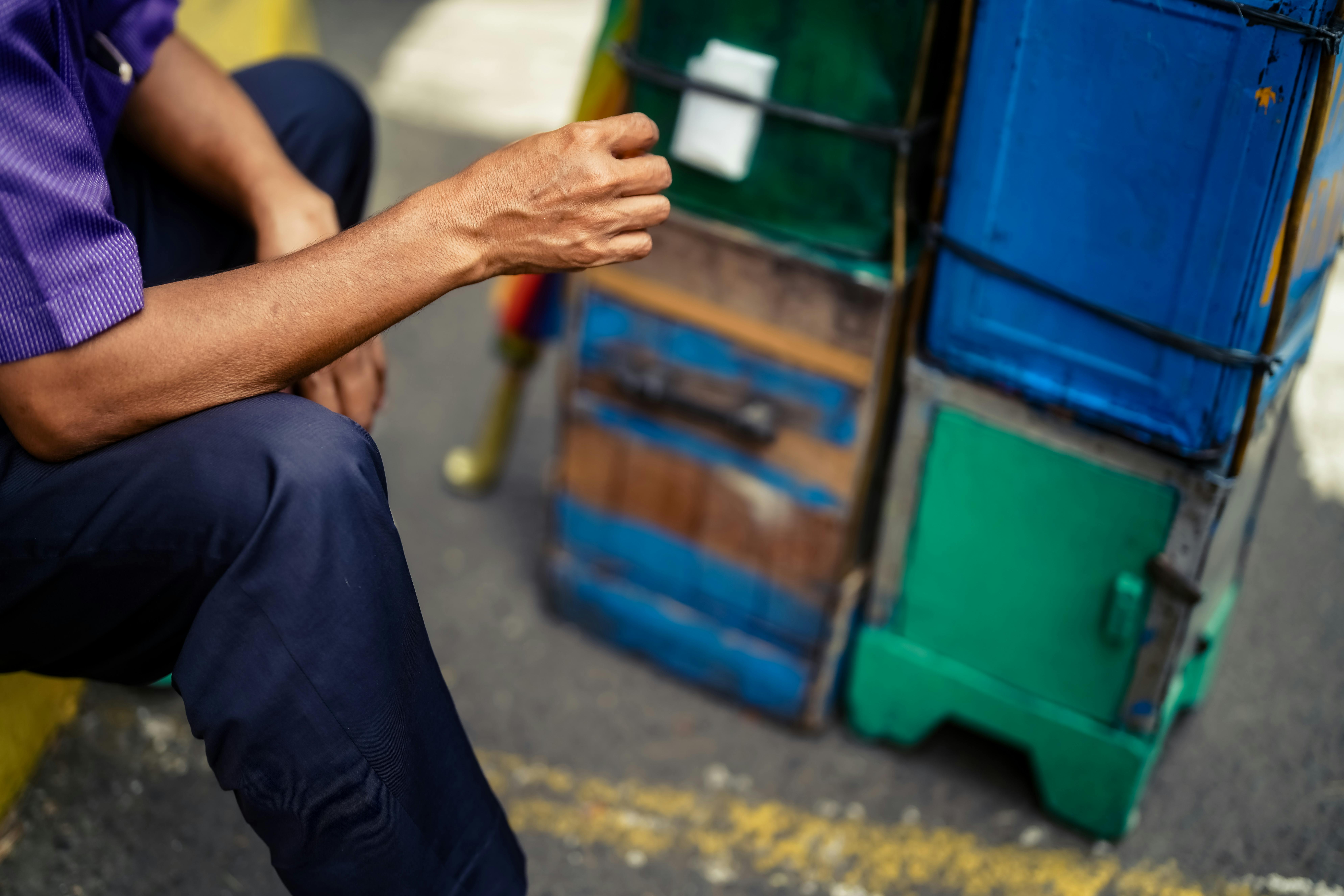 Gratis Nærbilde av en gateselgers hånd i nærheten av fargerike vogner på et marked i Jakarta. Arkivbilde