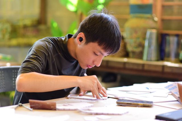 A teenager concentrating on a hands-on craft build at a worktable