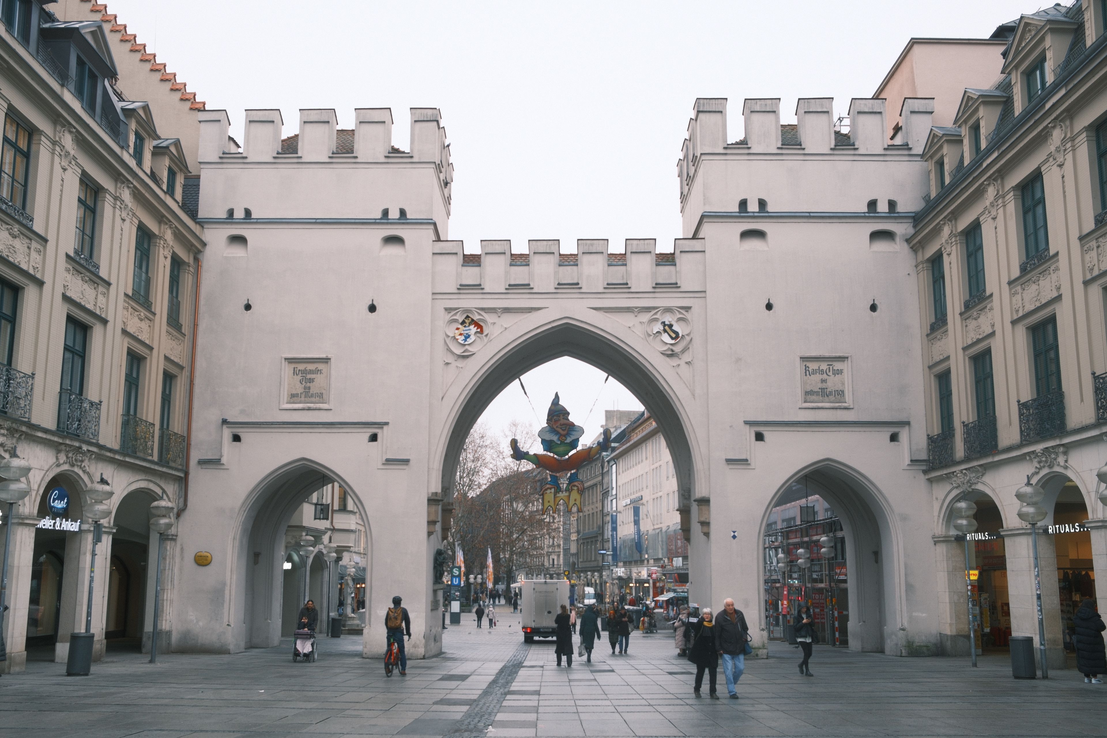 A bustling scene around Munich's historic Karlstor Gate.