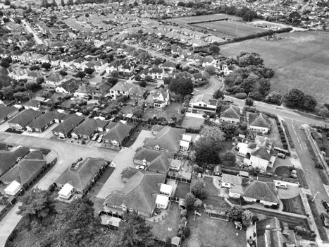 Aerial black and white view of a quiet suburban neighborhood showing houses and streets.