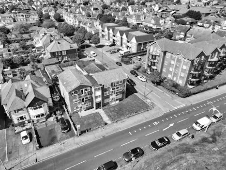 Aerial shot of a quiet residential neighborhood with classic architecture, captured in black and white for a vintage feel.